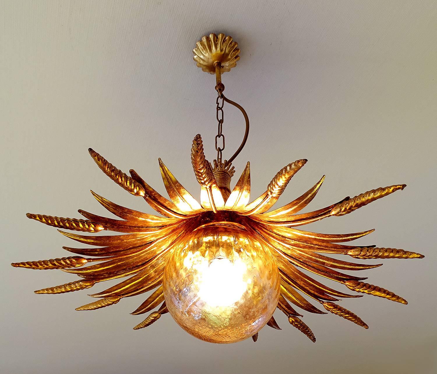 Large Sheaf Wheat chandelier arranged in a sunburst pattern, circa 1965s.
gold tinted blown glass globe with slight iridescent surface
The chandelier brings a cozy atmosphere in every room. 

Dimensions
21.65 in.H / 55 cmH
Diameter
21.65 in. (55