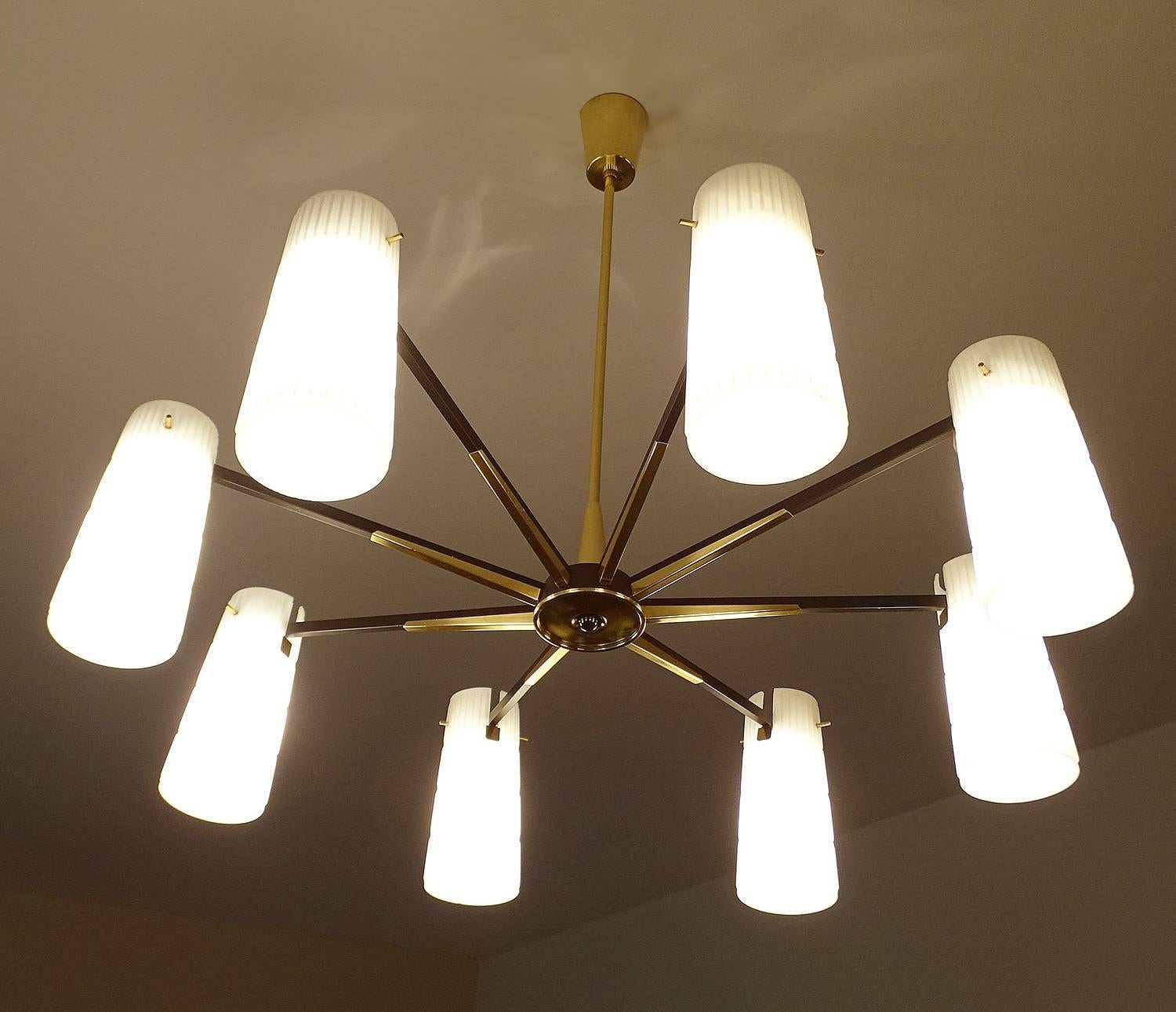 Large sunburst  chandelier, 1950s in a style reminiscent of Stilnovo and Arredoluce.  Satinated black structure with brass trims and central pod emulating a sunburst design, The diffusers are made from corrugated opaline glass 
29.53 in. / 75 cm