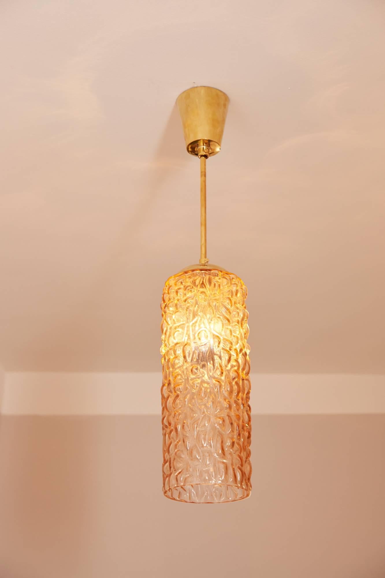 A set of three beautiful Austrian Mid-Century ceiling lamps, Prod. Rupert Nikoll Vienna, circa 1960, orange crystal glass tubes, cylinders, brass suspension, brass canopy, polished.
Adjustable length of the brass rods.
Cylinders height 35 cm,