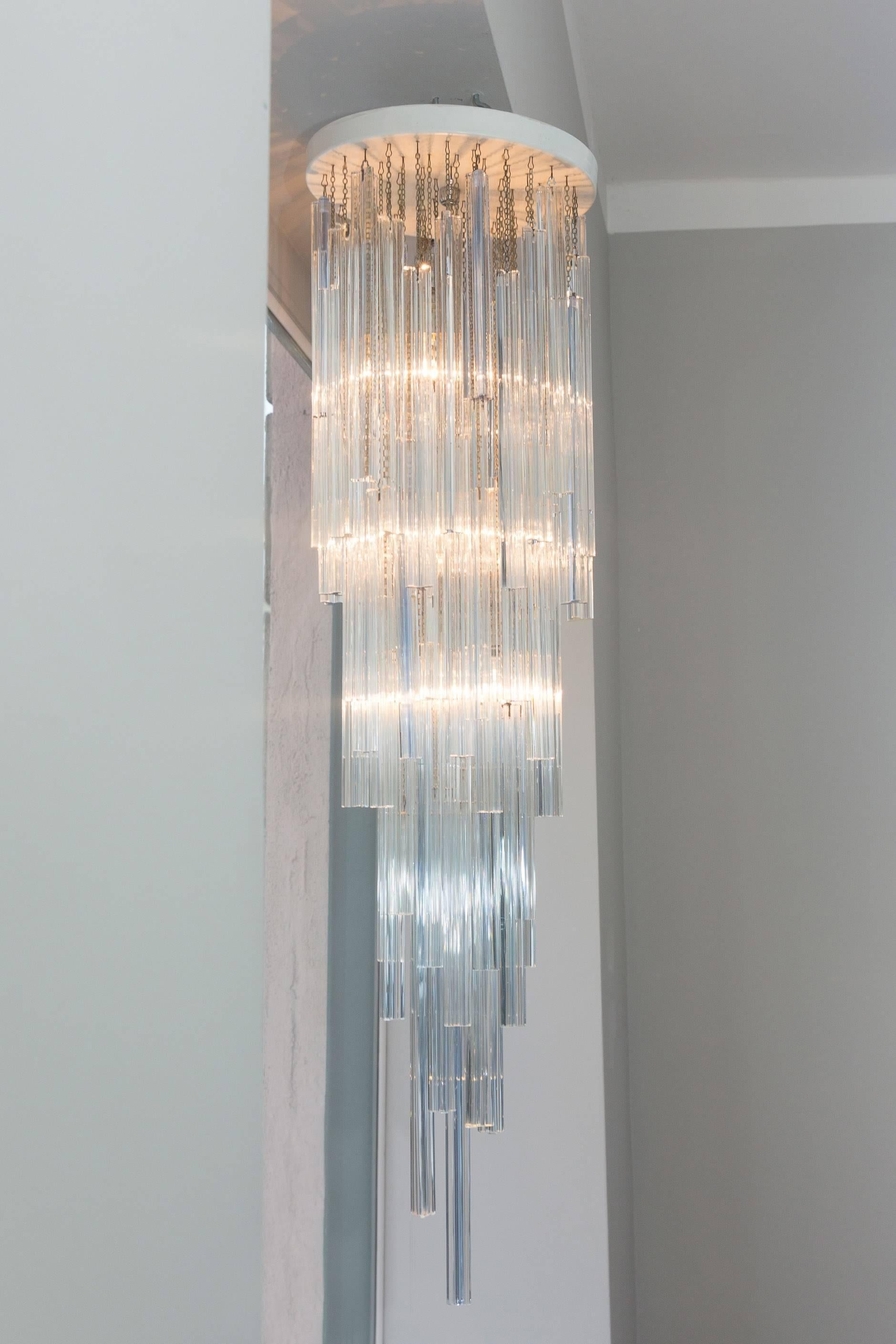 Elegant chandelier by Prod. Venini, Italy, circa 1970.
Series Trilobo transparent and aquamarine Murano glass, chromed metal chains, white lacquered metal plate, chrome light suspension, three bulbs, height 134 cm, diameter 36 cm.
Perfect