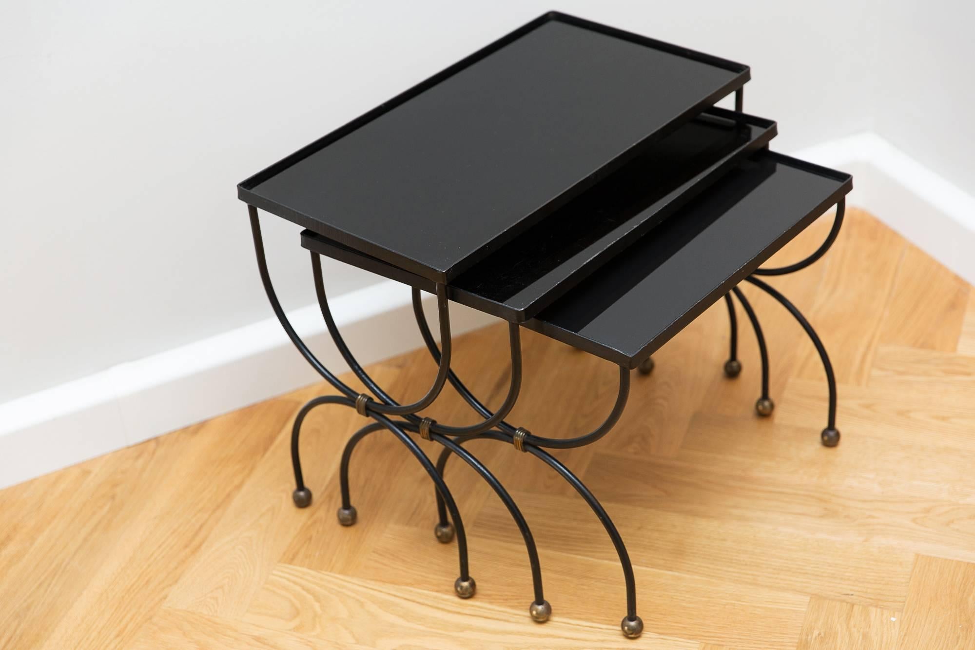 Set of three side tables, France, circa 1950, lacquered iron, brass, brass ball legs, black opaline glass tops.
Measures: Width 54 cm, 48.5 cm, 42.5 cm.
Height 44 cm, 40 cm, 38 cm.
 
