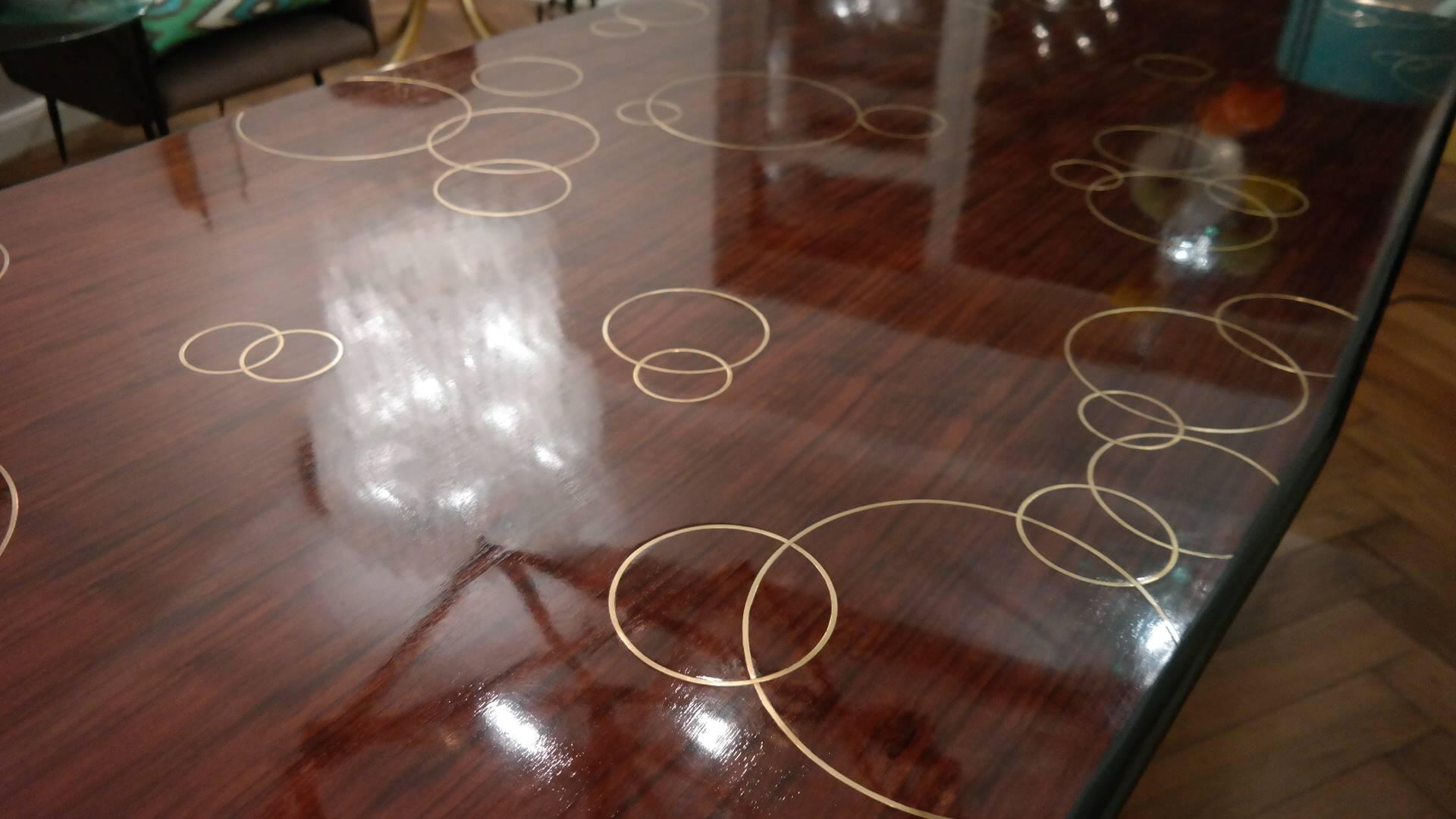 Elegant dining room table, Italy, 
Attribution to Carlo Alberto Bordogna, and possibly made by Colli, Torino, circa 1954
unique piece, very costly handmade tabletop with different polished brass circles inlays, polished walnut veneer, six different
