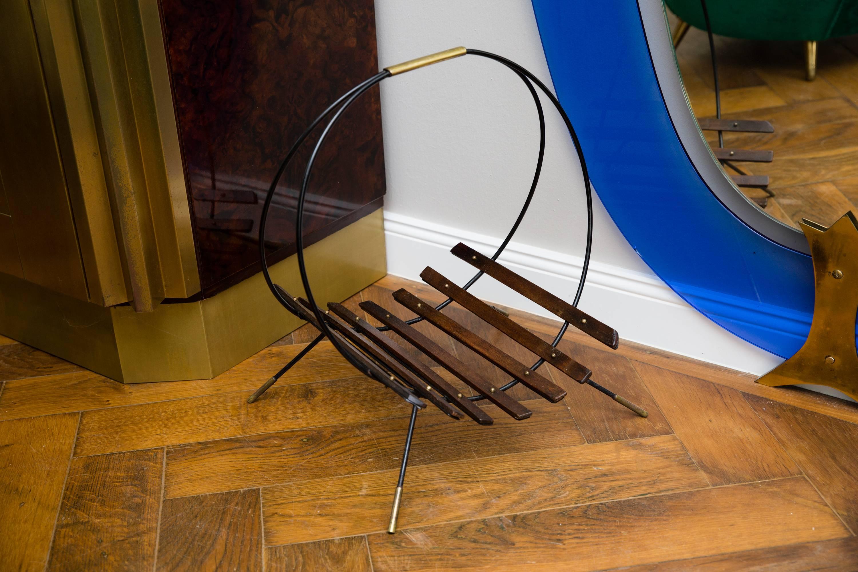 Elegant magazine or firewood rack, Austria circa 1950, black lacquered metal with brass feet, brass handle, mounted wood sticks fixed with small brass balls, restored.