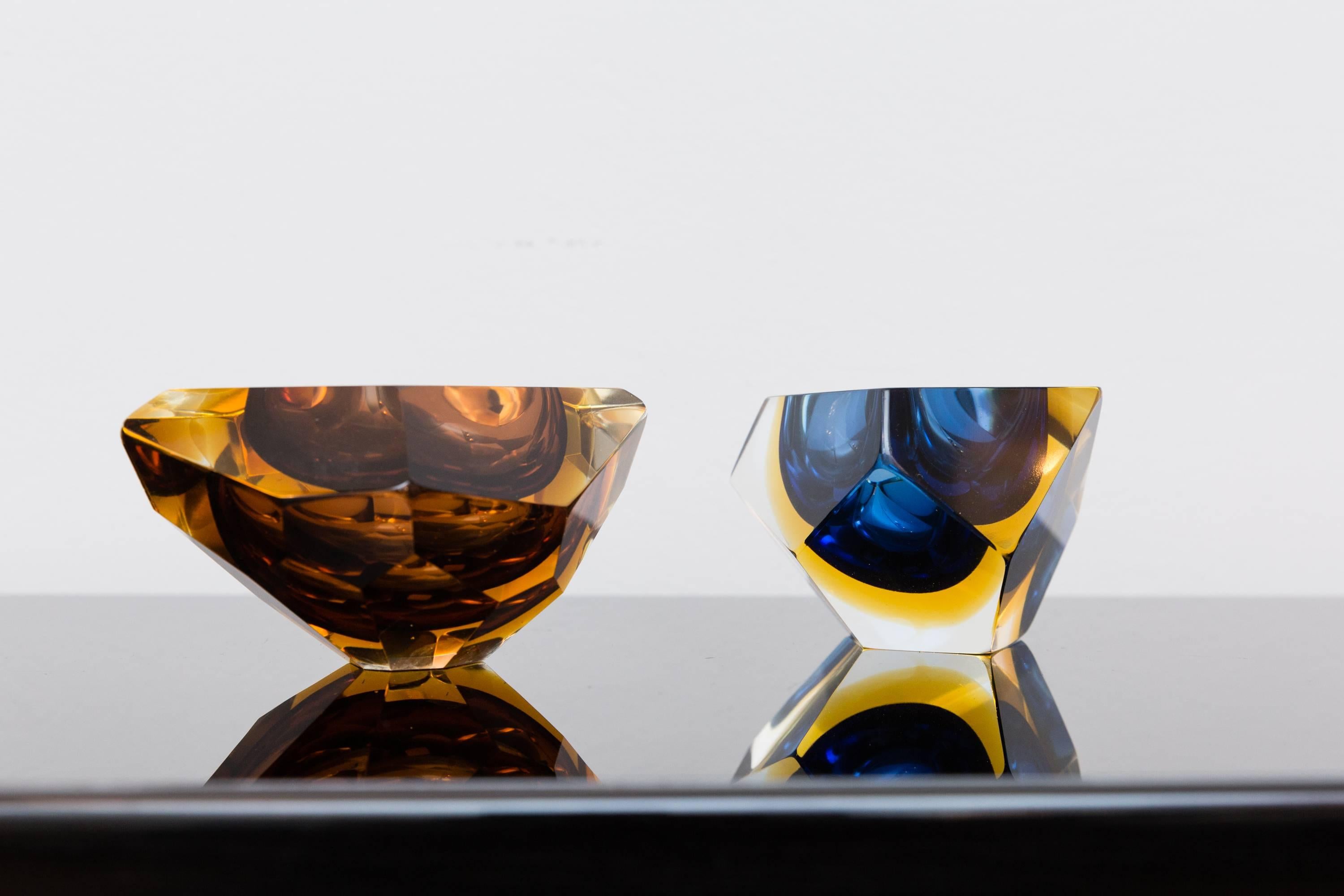 Beautiful multi-color set of two unusual faceted Bowls, Murano, Italy, circa 1960, Prod. Sommerso, different colors by orange, amber-yellow, blue, into clear glass. The vibrant colors and the different sizes make this pieces highly decorative.