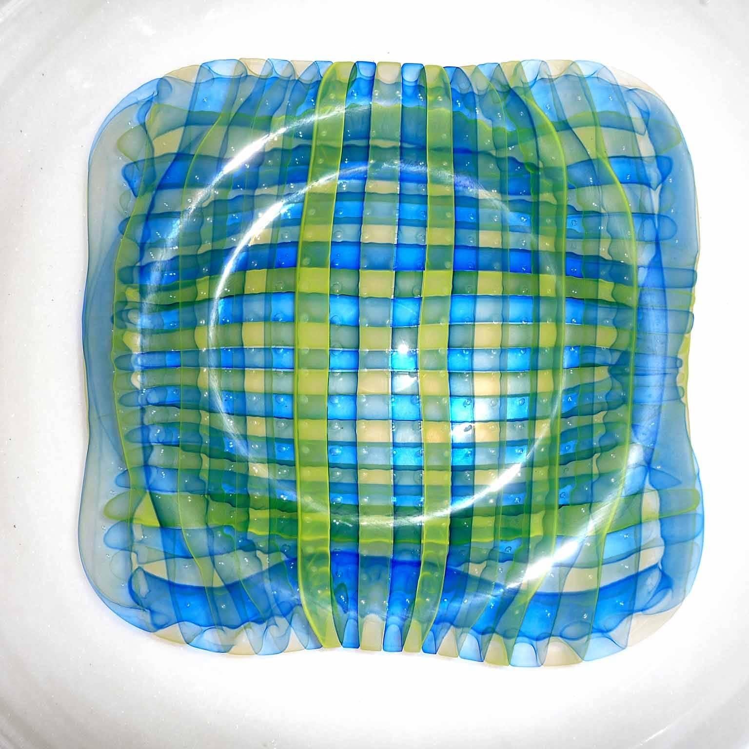 Huge decorative glass plate by Gary Beecham (b. 1955 Ladysmith, Wisconsin)

Colorless cameo glass, with two-layer band pattern in center, like a yellow and blue checkered cloth. Brushed stainless steel holder.
Signed and dated under the bottom