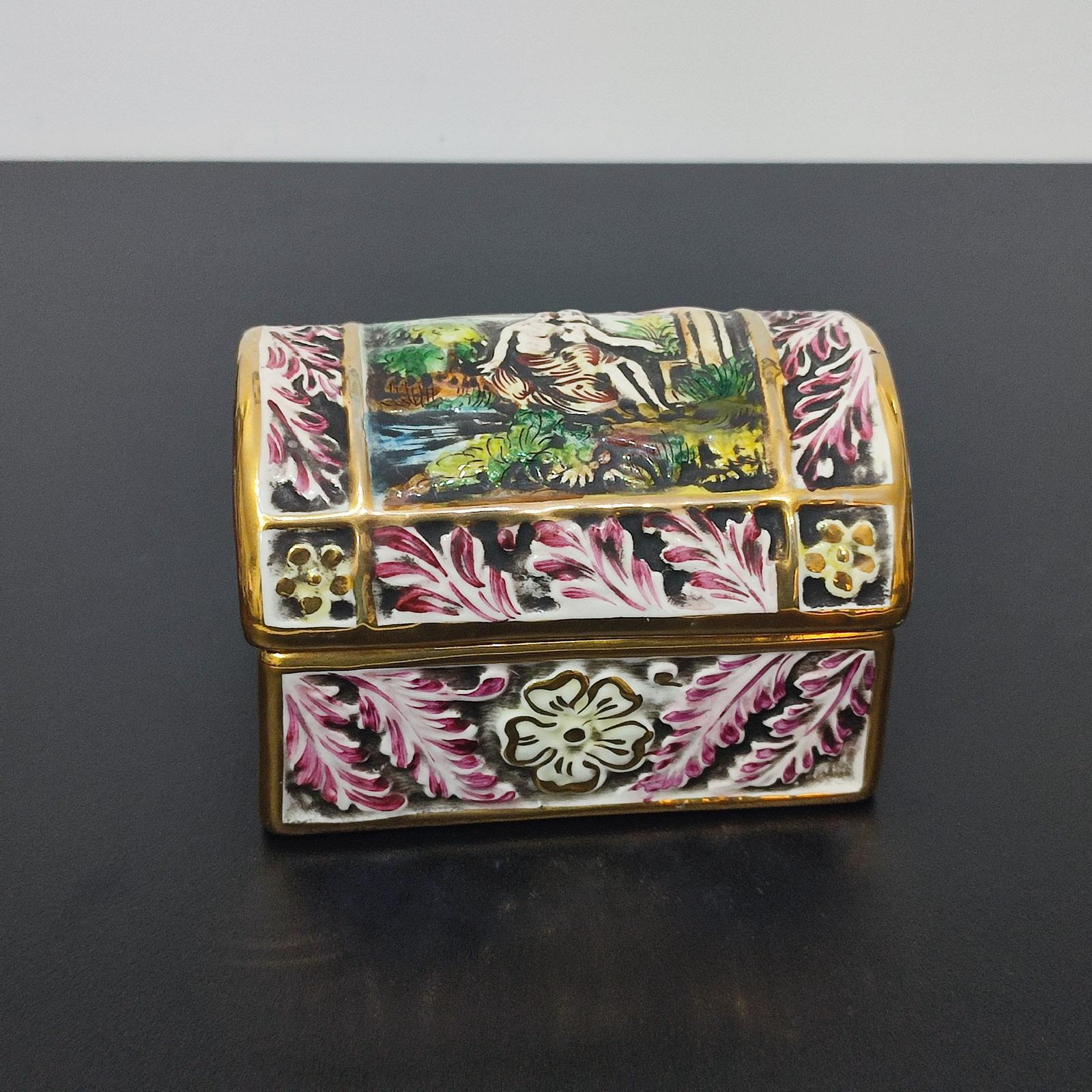 Coffre ou boîte à bijoux en porcelaine de Capodimonte du milieu du 20e siècle
Porcelaine émaillée avec marque sur la base.
Coffre à base rectangulaire avec couvercle bombé, décoré d'une scène galante.
Les côtés sont décorés de motifs floraux en