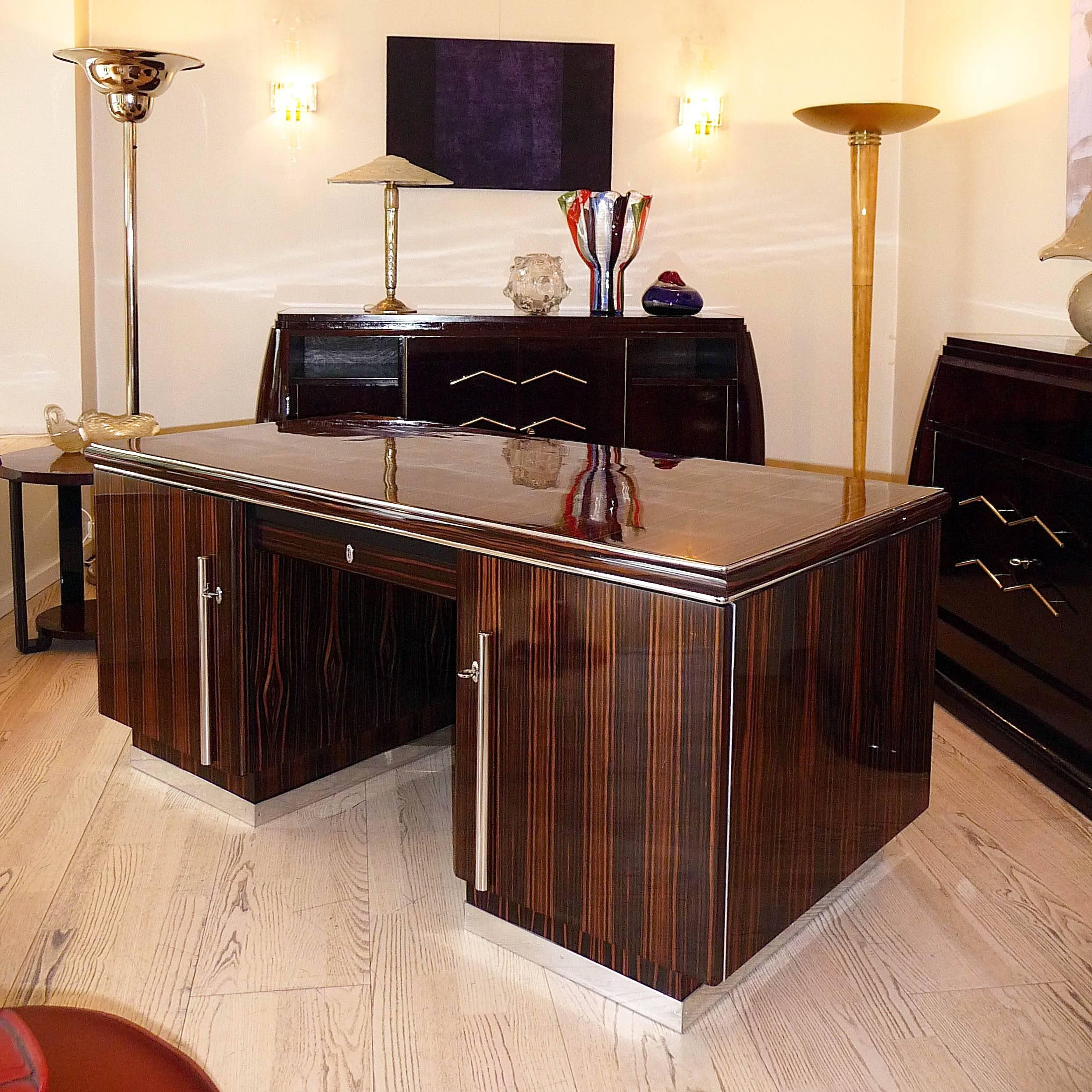 Art Deco Macassar Desk by Bruno Paul
Deutschen Werkstätten Hellerau, Germany, 1935

Body in oak with macassar veneer. Decor elements in polished aluminum.
Two doors and one middle drawer. One compartment with shelf in the front of the