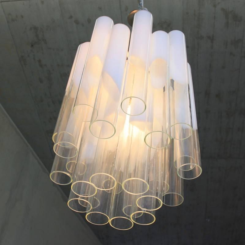 Tubular glass chandelier designed by Aldo Nason for Mazzega, Italy, 1970s.

24 long glass tubes with crowned in white towards the top of the glass, metal frame with five light sockets.