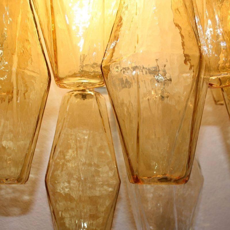 Pair of wall scones, designed by Carlo Scarpa for Venini, Italy.

Cream colored structure with polyhedral shaped glass pieces in amber, clear glass. Re edition of the 1940s design. Murano, Italy.
   