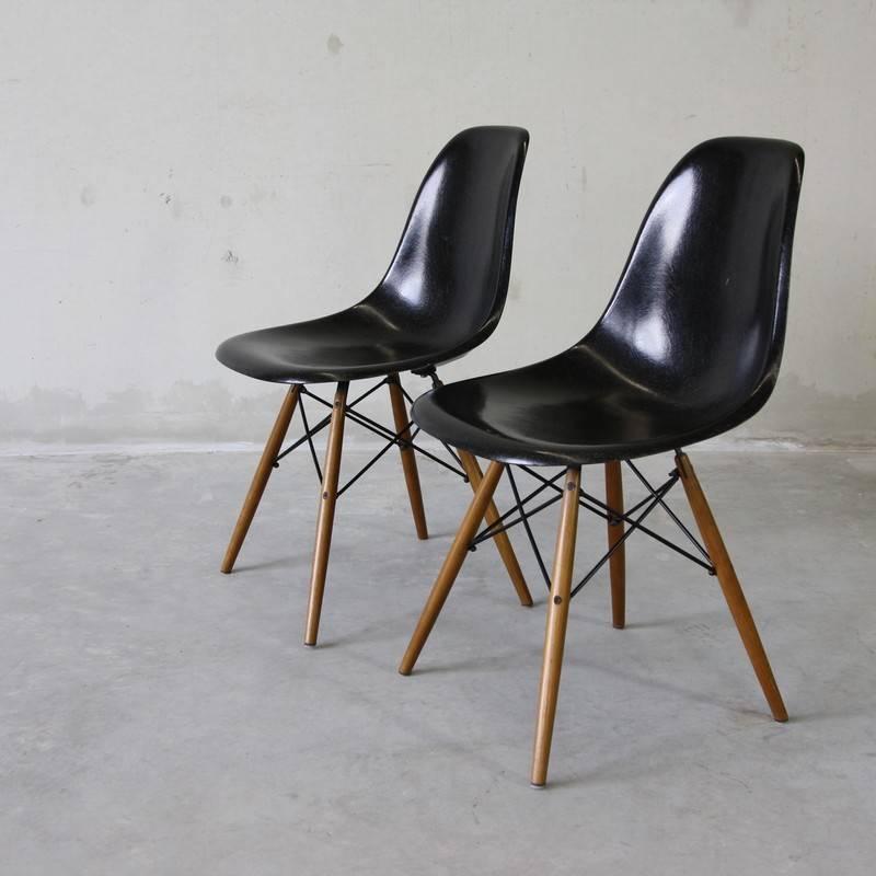 Set of four side chairs designed by Charles and Ray Eames, 1960s.

Four black fibreglass side chairs with walnut base, marked 'Herman Miller, Fehlbaum Production' on the underside.