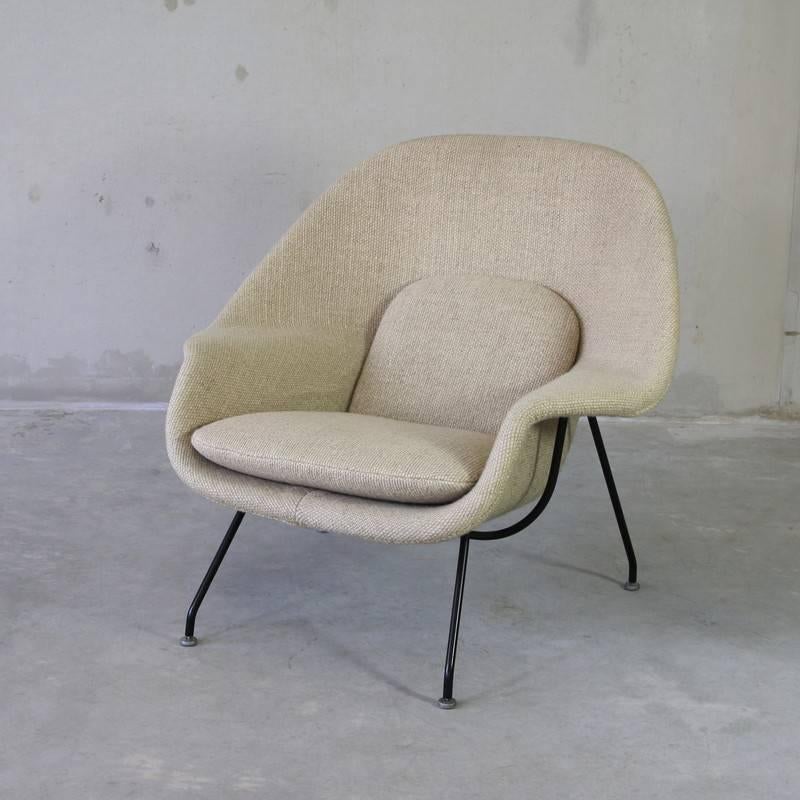 Womb chair with ottoman designed by Eero Saarinen, U.S.A., Knoll International, 1948.

Black metal frame with heavy woven cream colored wool upholstery. There is some very slight discoloration on the underside of the cushion of the foot stool,
