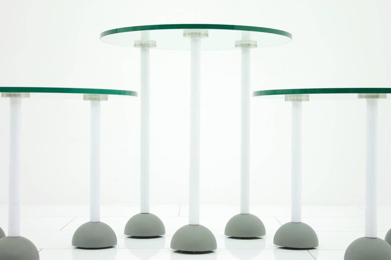 Set of three glass tables with wheels, Memphis, 1987. Marked with 7 1987. 

Very good condition. 
Measures: Diameter 50 cm, height 1 x 54 cm, 2 x 39 cm.
