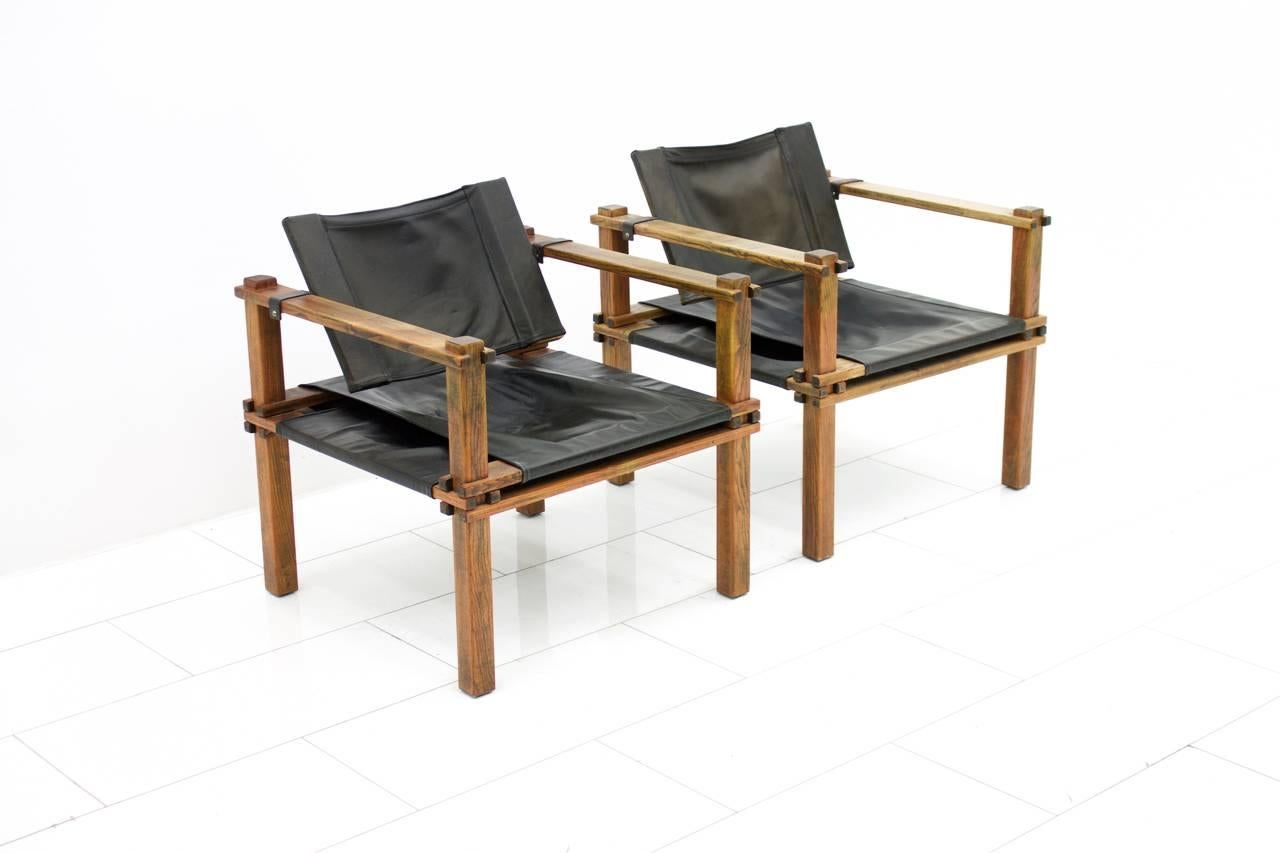 Set of Two safari chairs in dark Oak and black leather.
Designed by Gerd Lange 1965 and made by Bofinger, Germany.
Measurements: D 65 cm, W 65 cm H 70 cm, SH 37 cm.

Good original condition with a beautiful patina.