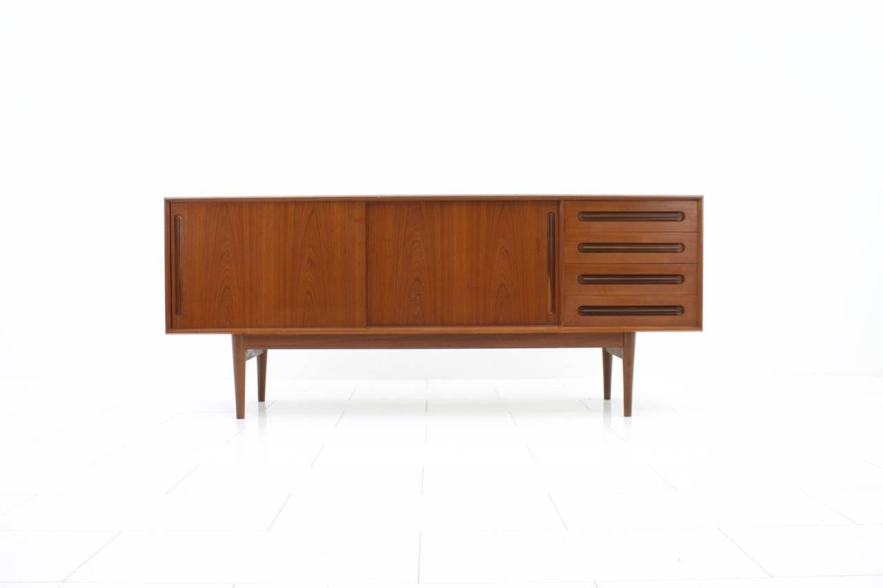 Nice teak wood sideboard by Central Møbler, Denmark 1960s. Four drawers and two sliding doors with beautiful teak grips.
Very good condition.

Worldwide shipping.