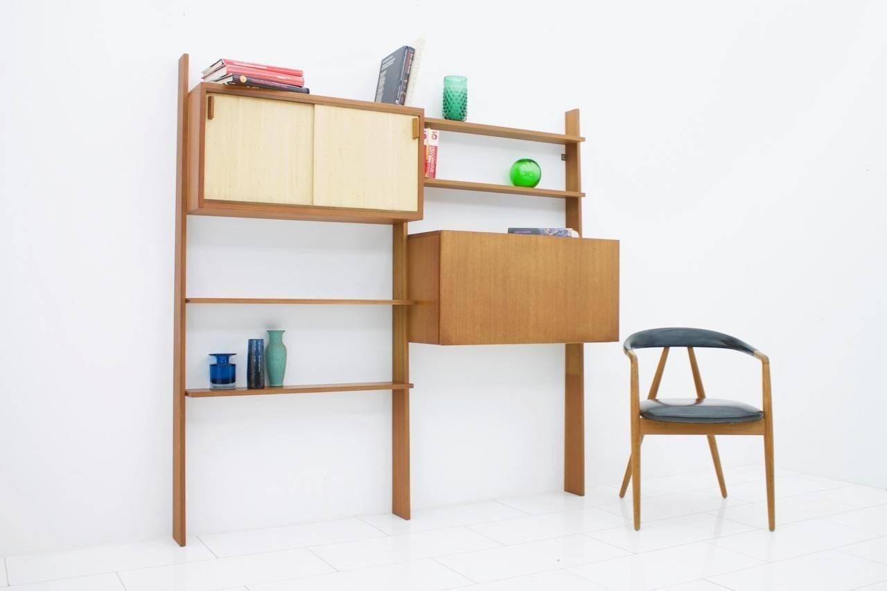 Rare teak shelf system by Dieter Waeckerlin with seagrass sliding doors.
One cabinet with a bar or a desk and one cabinet with two sliding doors.
Measurements: W 178 cm, H 175 cm, D 38 cm.
Good condition.

 