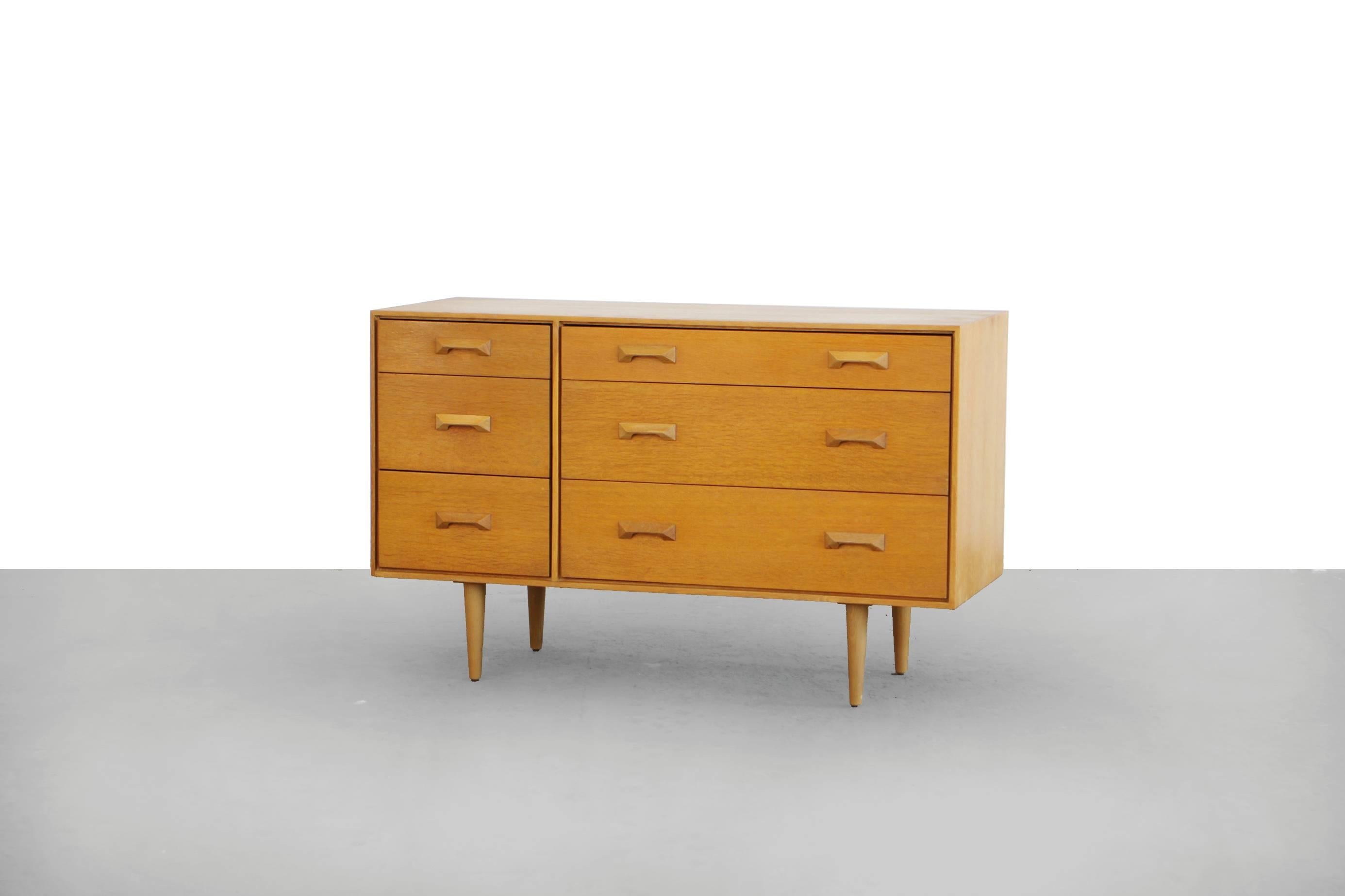 A fabulous chest of drawers by the highly regarded John & Sylvia Reid. Manufactured by Stag this is from the 'Concorde' range. Made with oak veneers, it has beautiful handles. In very good vintage condition with a few scratches and repaired spots.