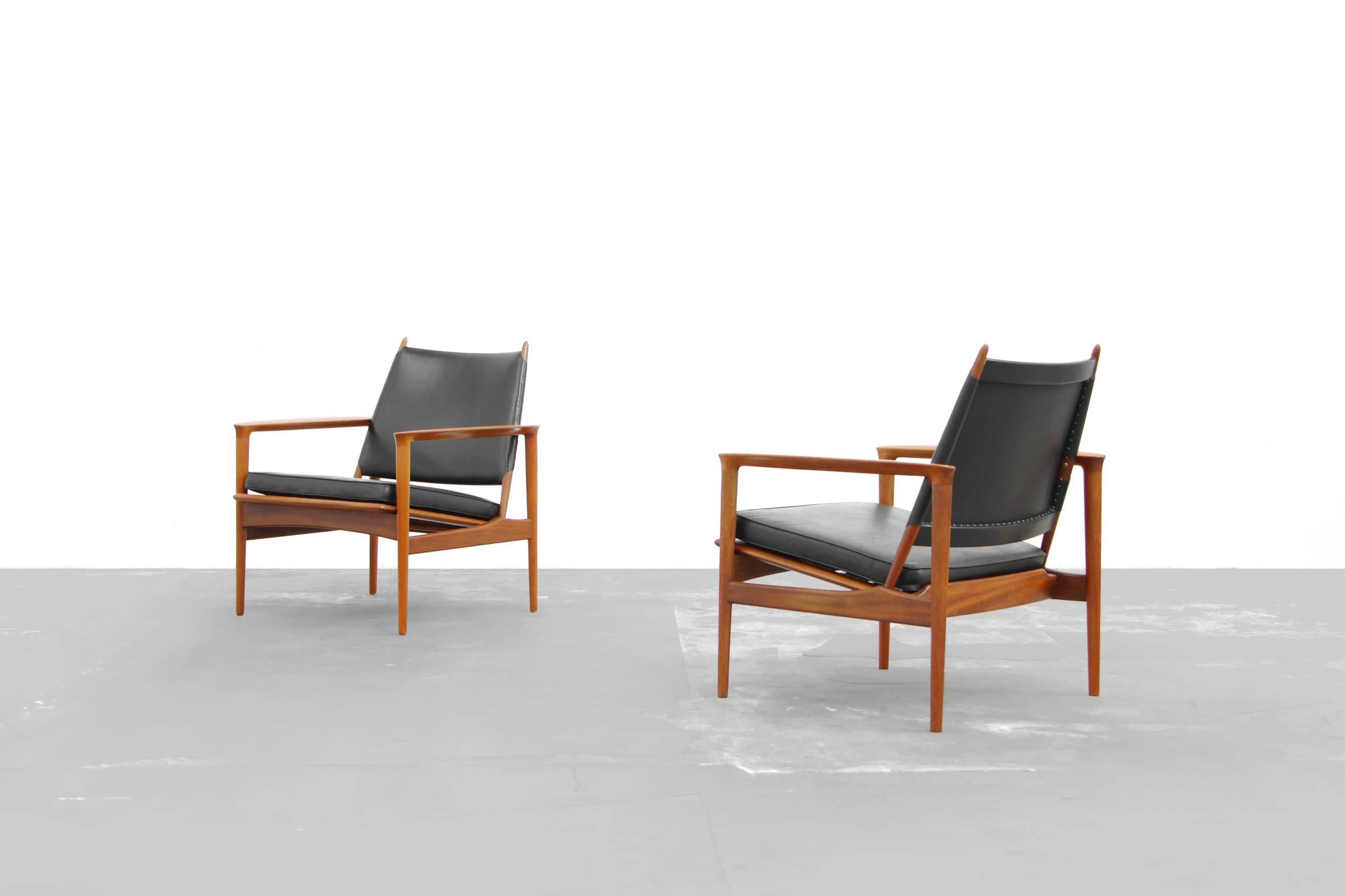 Very nice sculpted pair of easy chairs, Model Broadway by Torbjørn Afdal for Svein Bjørneng. Design of 1958. Construction teak with loosely placed pillows. Very nice original condition with charming patina.