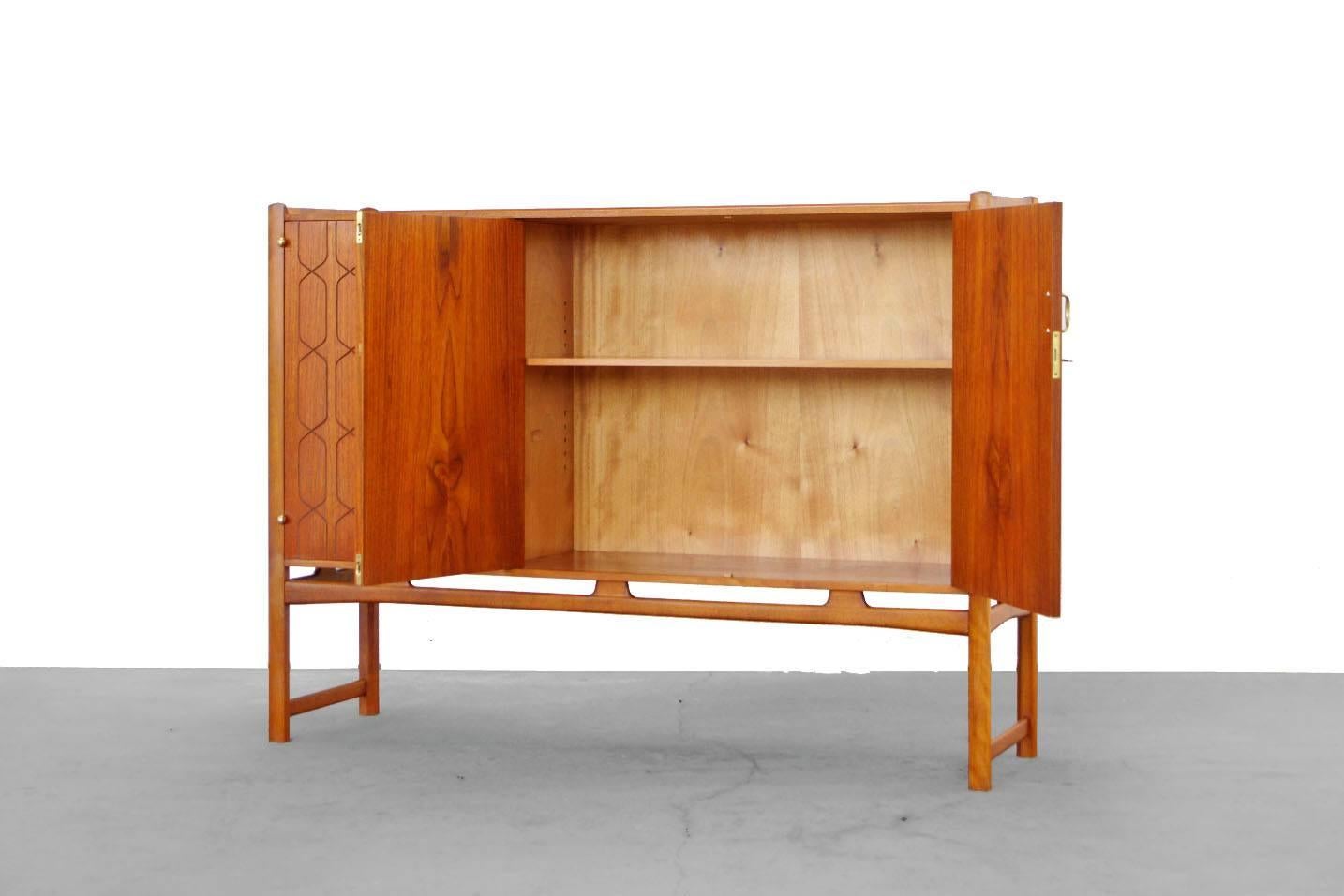 A unique Highboard by David Rosén for Nordiska.
This charming cabinet is very well crafted and is highllighted by
the gorgeaus material selection, unique brass hardware, solid teak and beech wood mix. A highlight is the engraved pattern on the