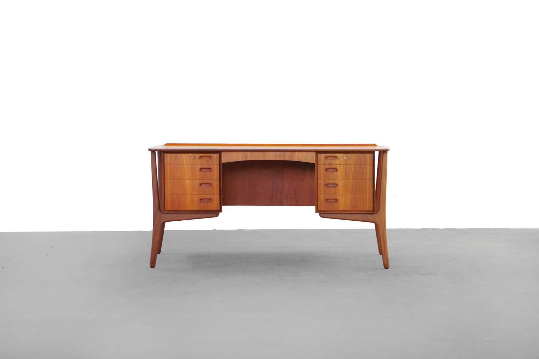 Freestanding teak desk by Svend Aage Madsen, Denmark. Beautiful curved plate with fillet edge, front with six drawers, backside with pocket, curved outwards on floating legs. Good condition, one plate behind is missing.