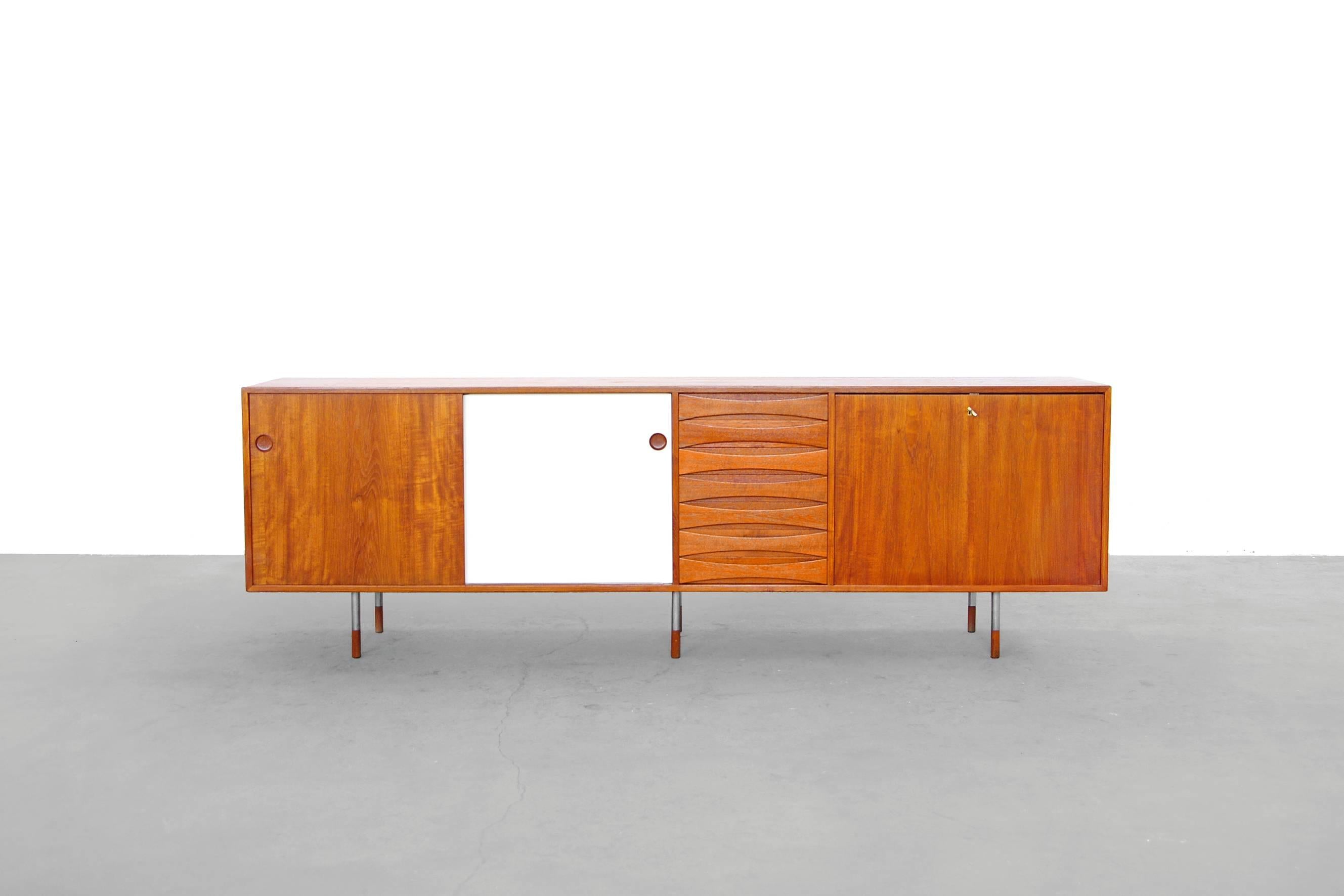 Rare teak A29 sideboard by Arne vodder for Sibast 1959.
With two colored reversable sliding doors, 7 drawers and one lockable clap door. This model comes with beautiful slender metal-wood feets.
The condition is overall good. Some repaired spots