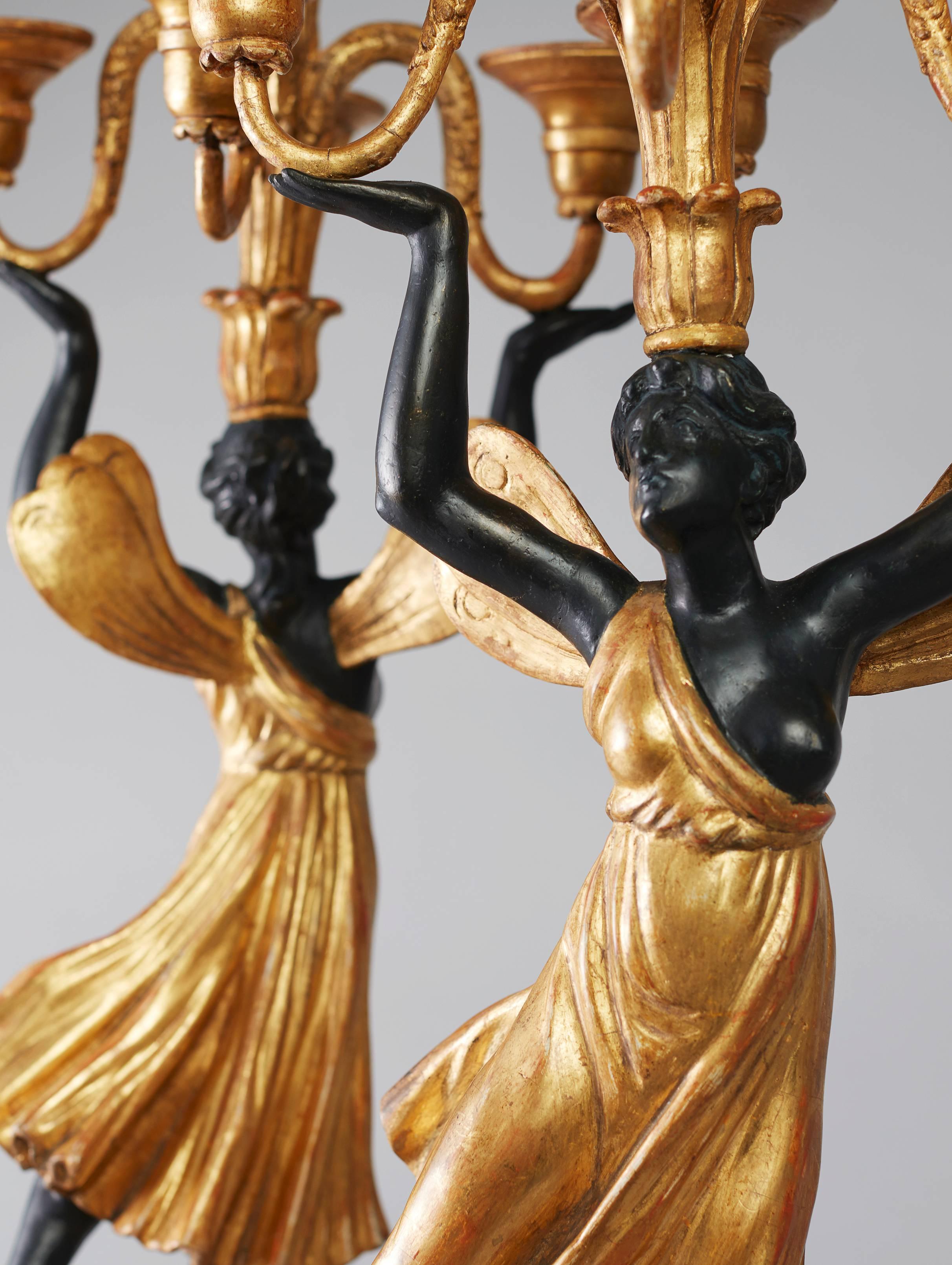 Each modelled as a semi-draped female figure holding aloft four scrolled branches and a central finial, standing with one foot on a round sphere pedestal with decoration of shells and dolphins.

The Austrian Museum of Applied Arts in Vienna (MAK) is