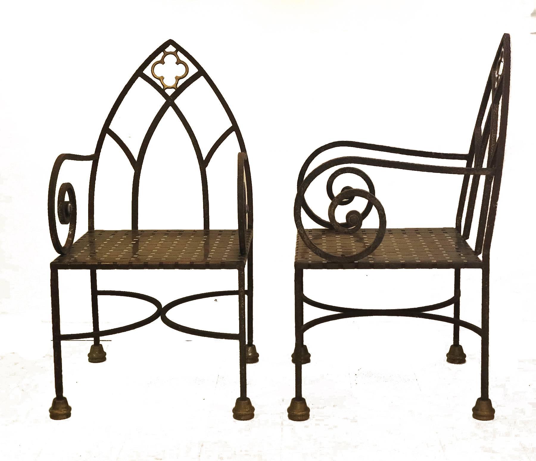 Pair of heavy iron with brass details Gothic style chairs. Woven brass seats arched back design with brass detail.