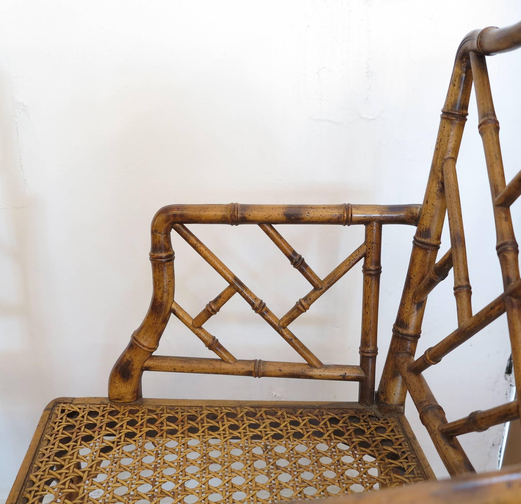 Pair Faux bamboo armchairs with cane seats. Good original finish with original seat cushions. From the 80s side or dining chairs.