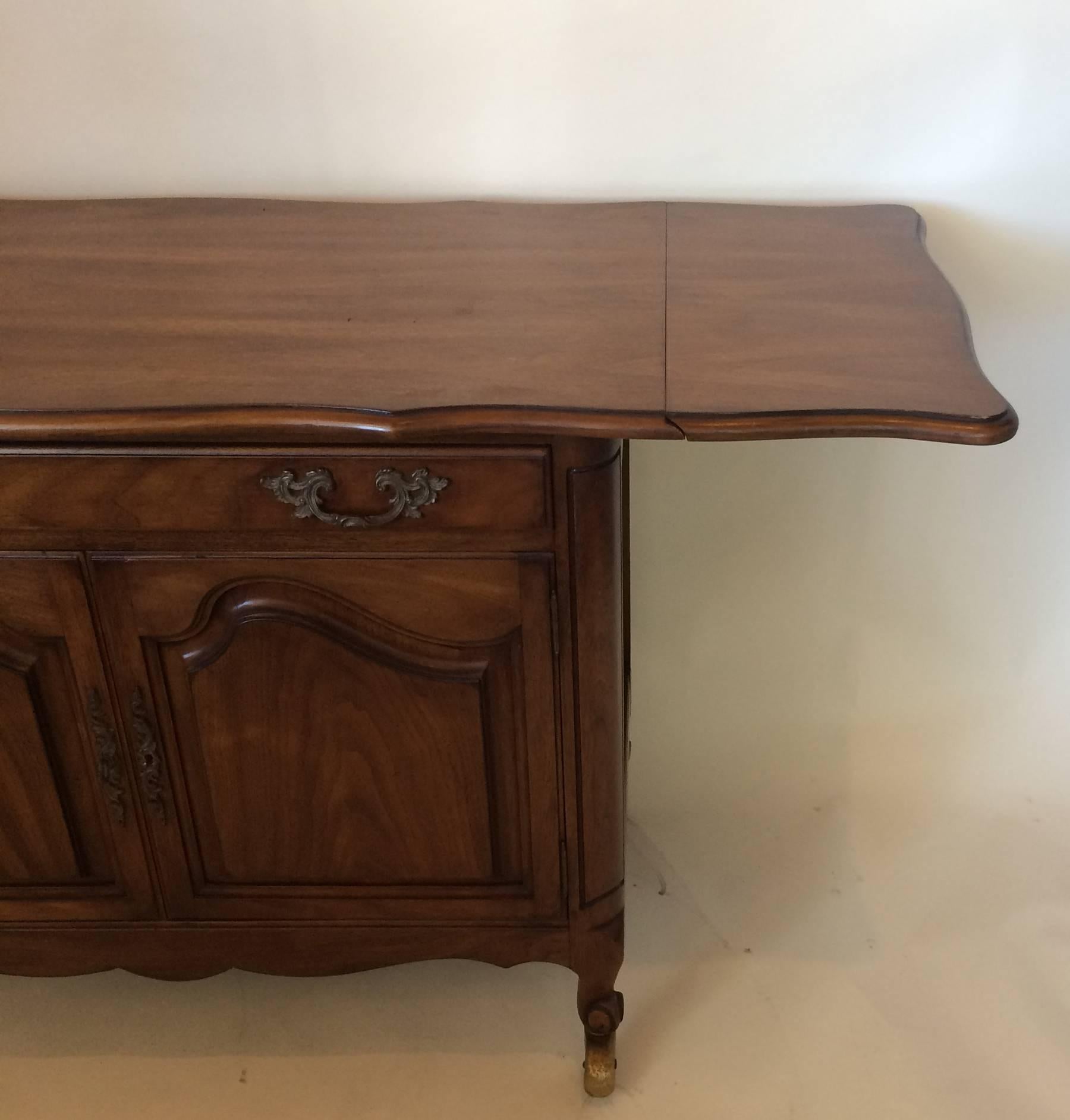 Vintage French Provincial style tea cart server. Dining room furniture. Could be used as a bar cart. Has fold down ends which make the server 56 inches wide when opened.