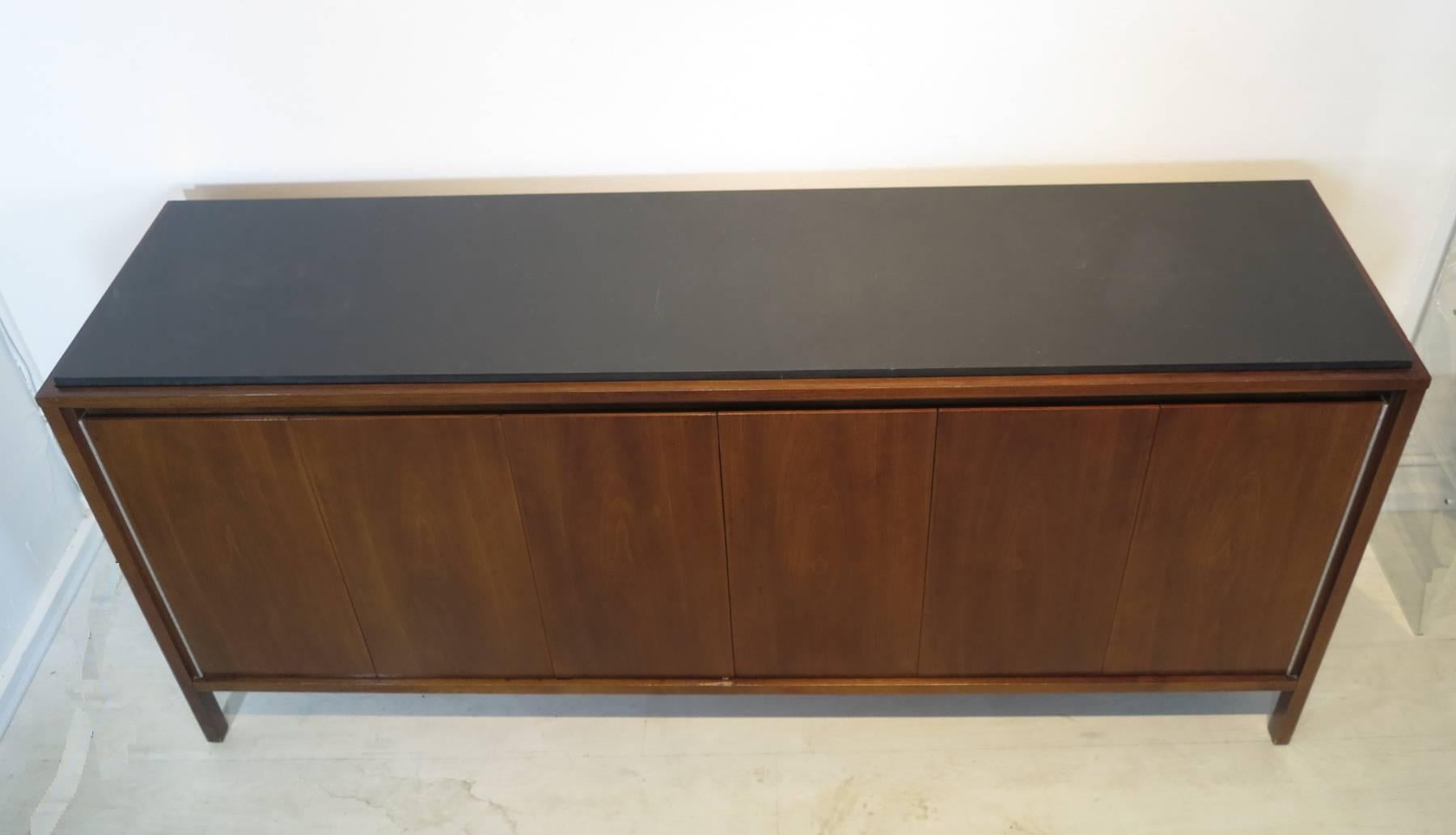 Beautifully designed streamlined modernist cabinet by Paul McCobb for H. Sacks & Sons Connoisseur collection. This elegantly crafted work has six (6) richly grained book matched walnut doors with no exposed hardware that open to reveal two (2) large