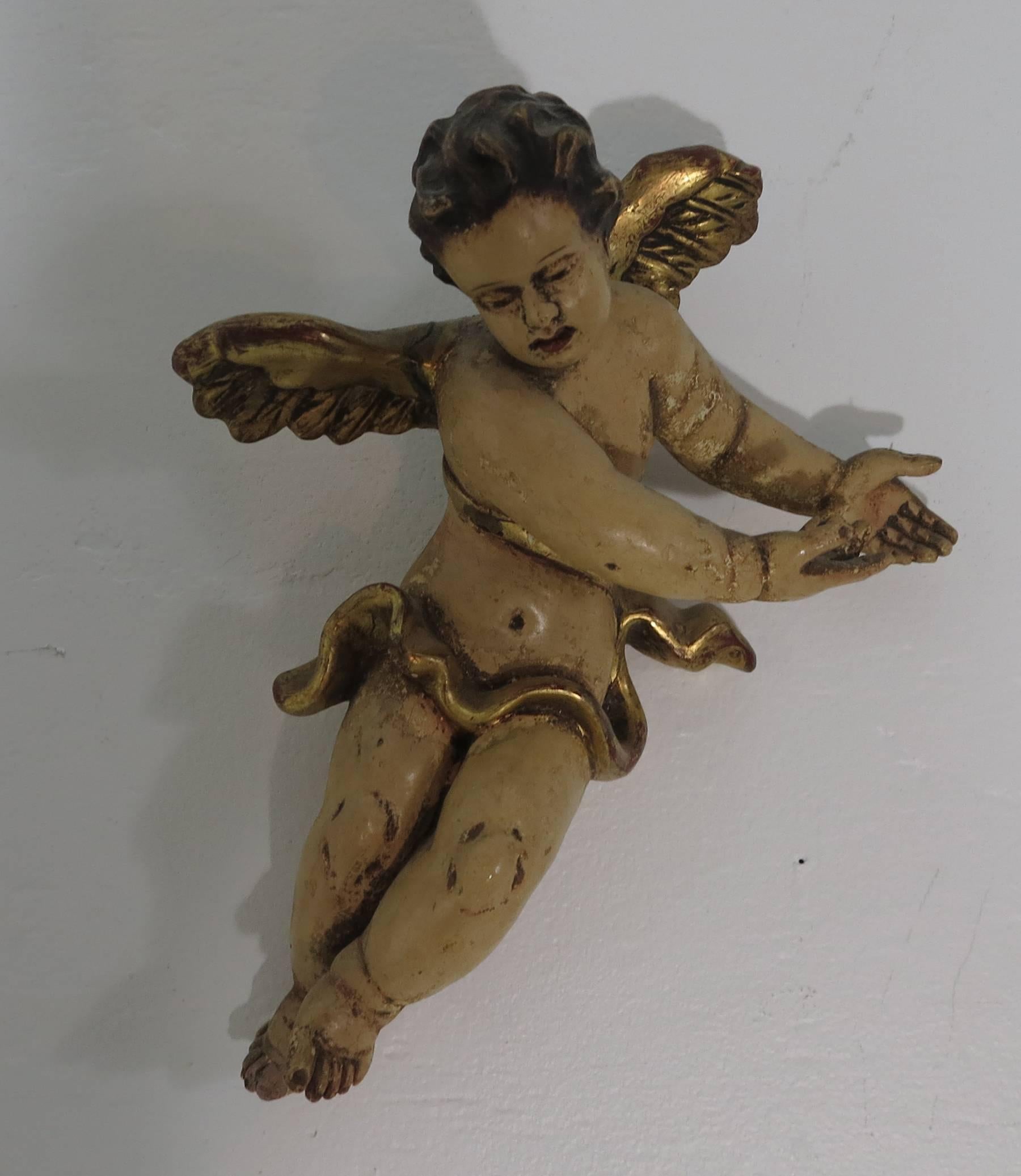 Pair of poly-chromed wall hanging craved wood putti. Probably Italian