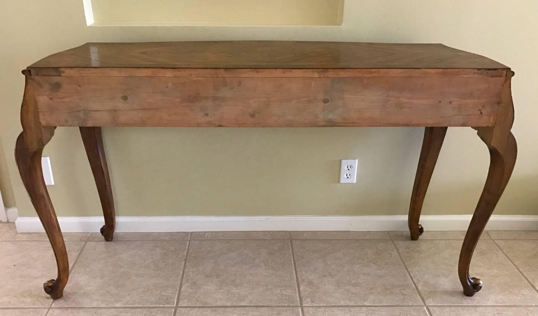 Handmade wooden console in the Italian Rococo style. From the 1980s entirely handmade and hand craved probably made in Italy. Pine secondary woods with exotic veneers. Measures: Approximately 61 inches wide by 20 deep 35 inches high.