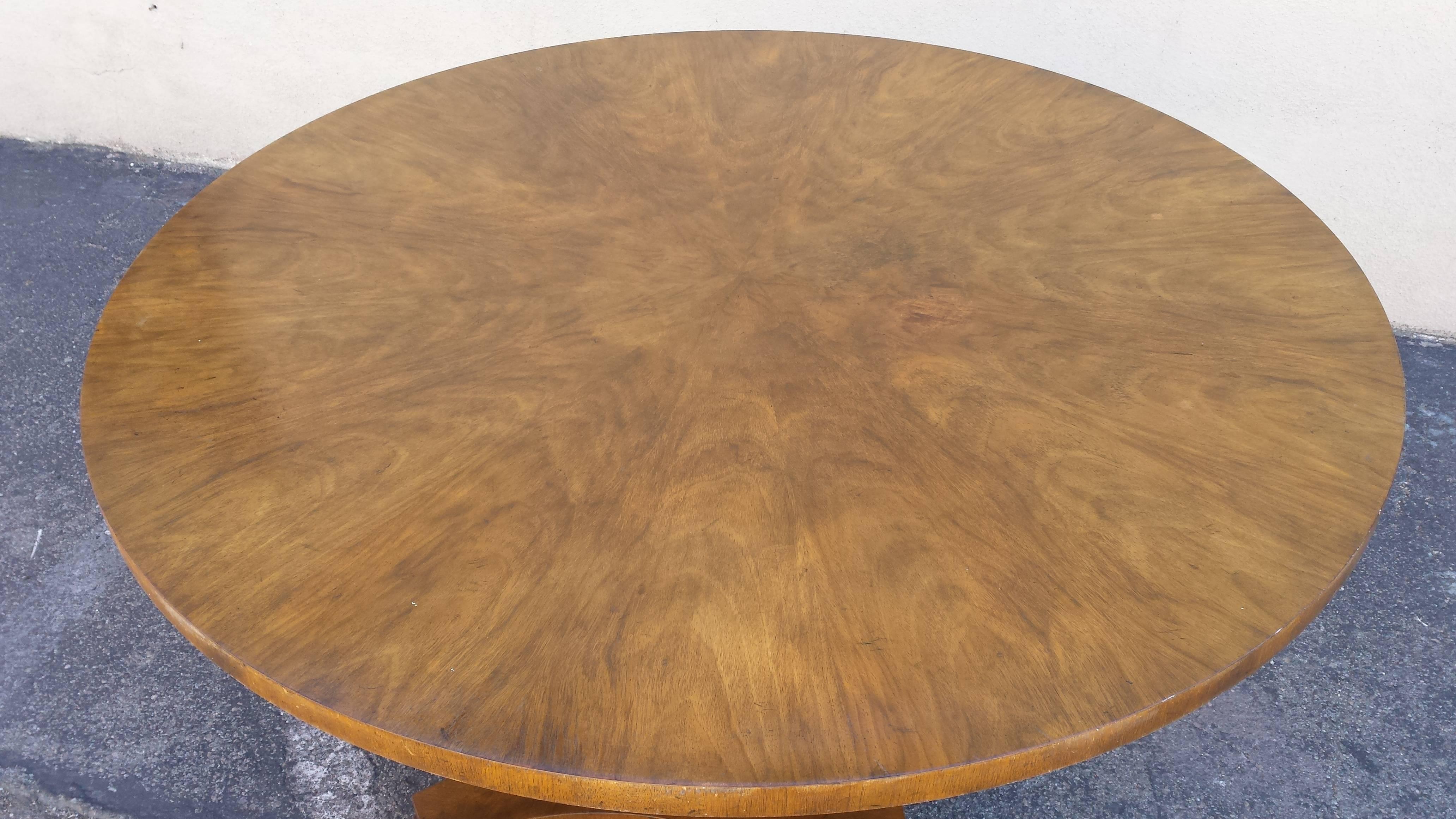 Beautiful center table made by Baker. Made from burl wood. the round sleek top sits on an sculptured pedestal base.
