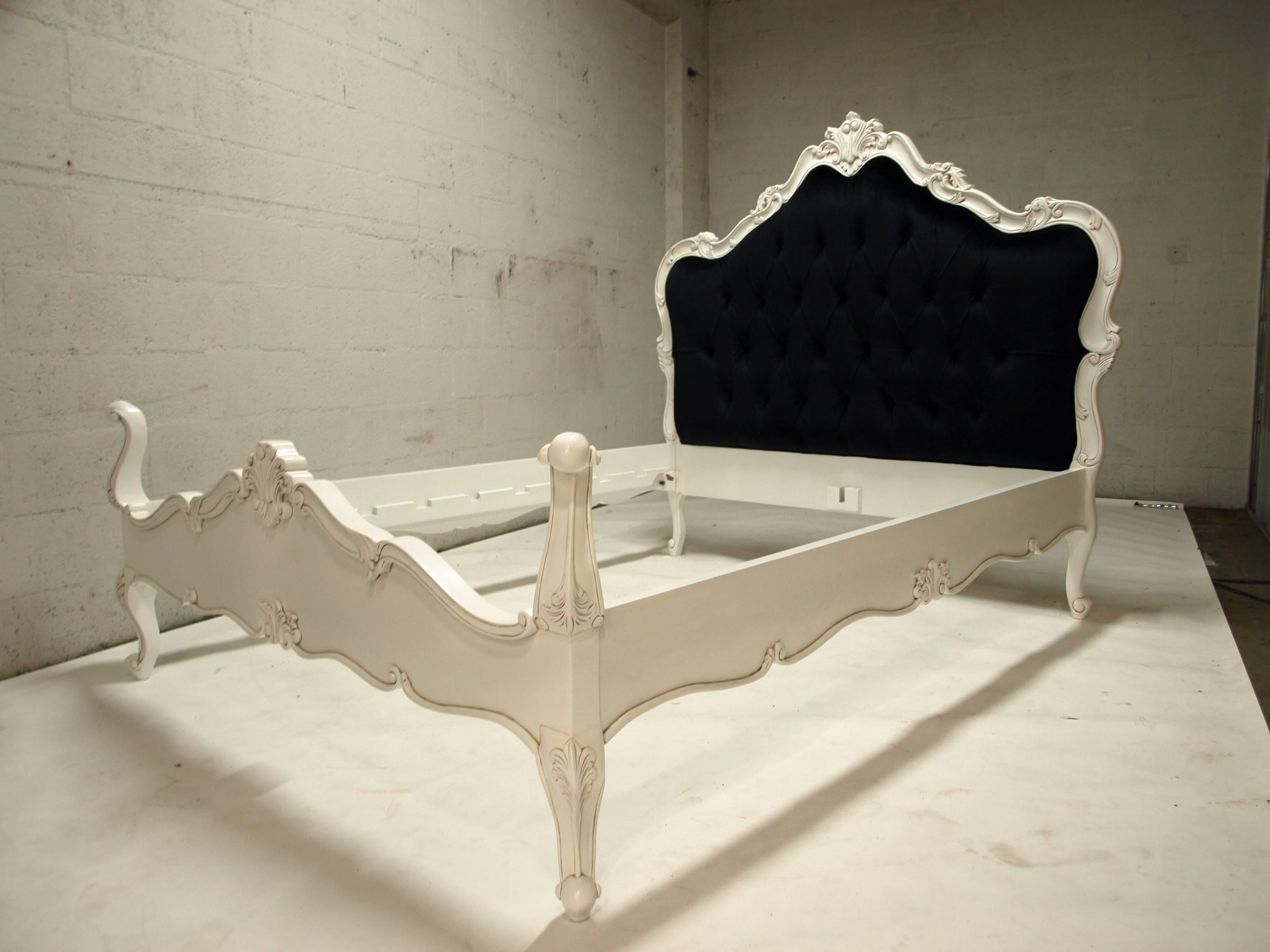 Beautiful bed in the French Louis XV style. Made from solid mahogany wood and newly painted in white finish. Hand carvings are shown. The headboard comes in a black velvet fabric and deep tufted. This bed will fit a standard queen-size, mattress