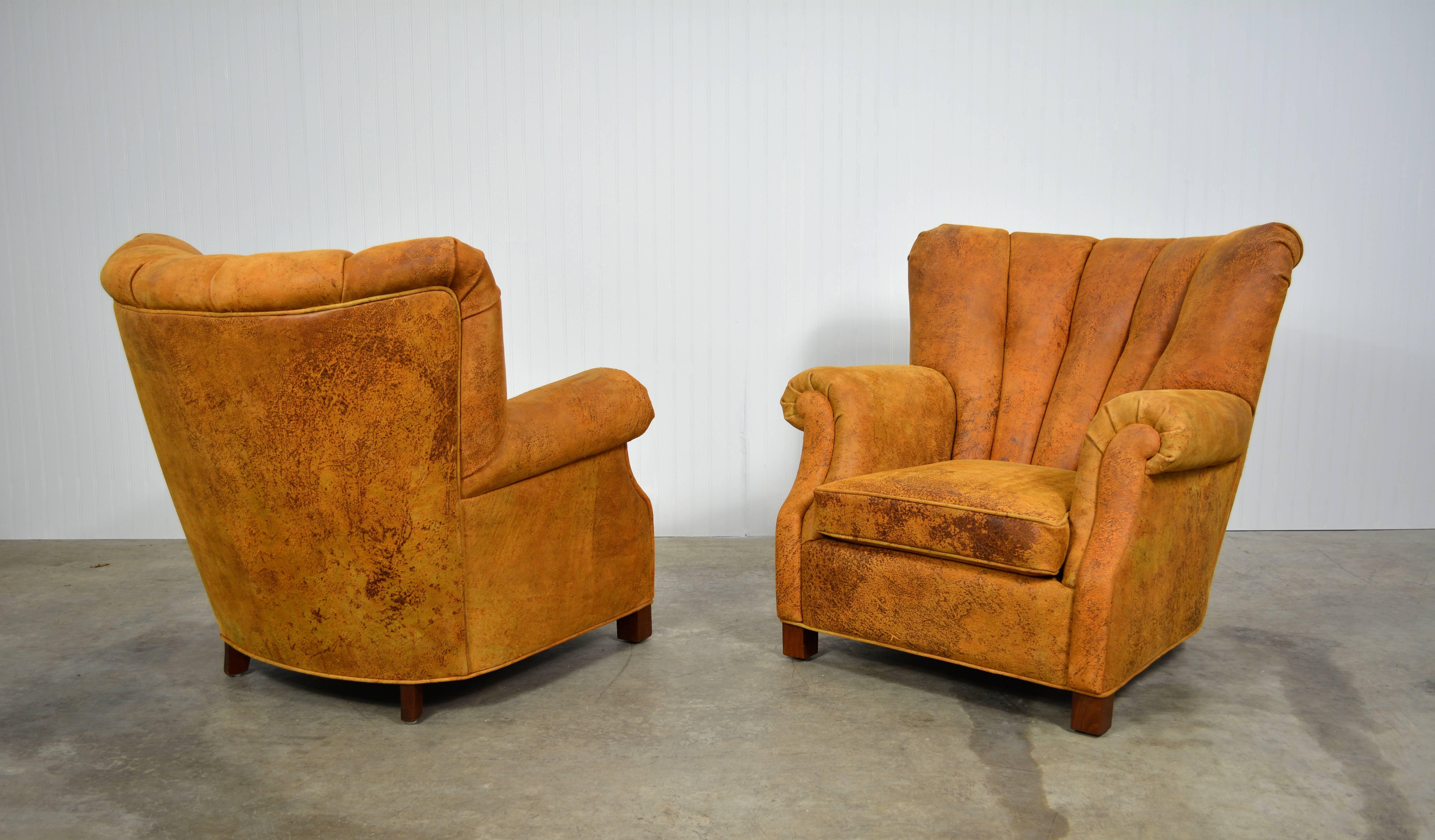 A stunning pair of early and rare channel back lounge chairs by Fritz Hansen. Designed in 1942, as shown in the Fritz Hansen catalog from that year. The patina on the leather makes these chairs exceptional. A great example of early Danish Modern