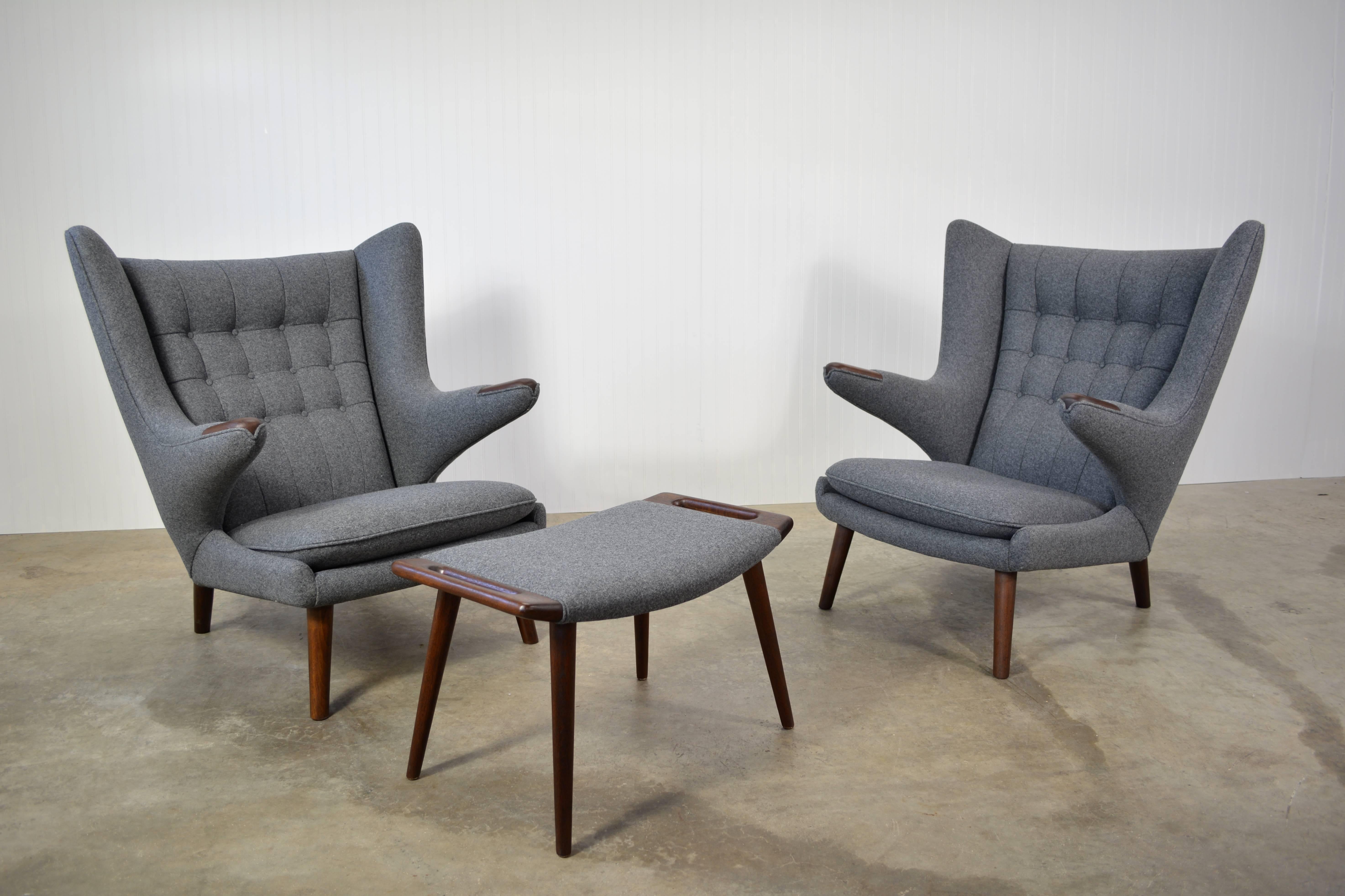A pair of Hans Wegner "Papa Bear" chairs designed in 1951. Newly restored and recovered in Maharam "Divina Melange". Teak legs and paws. A single matching ottoman is included.