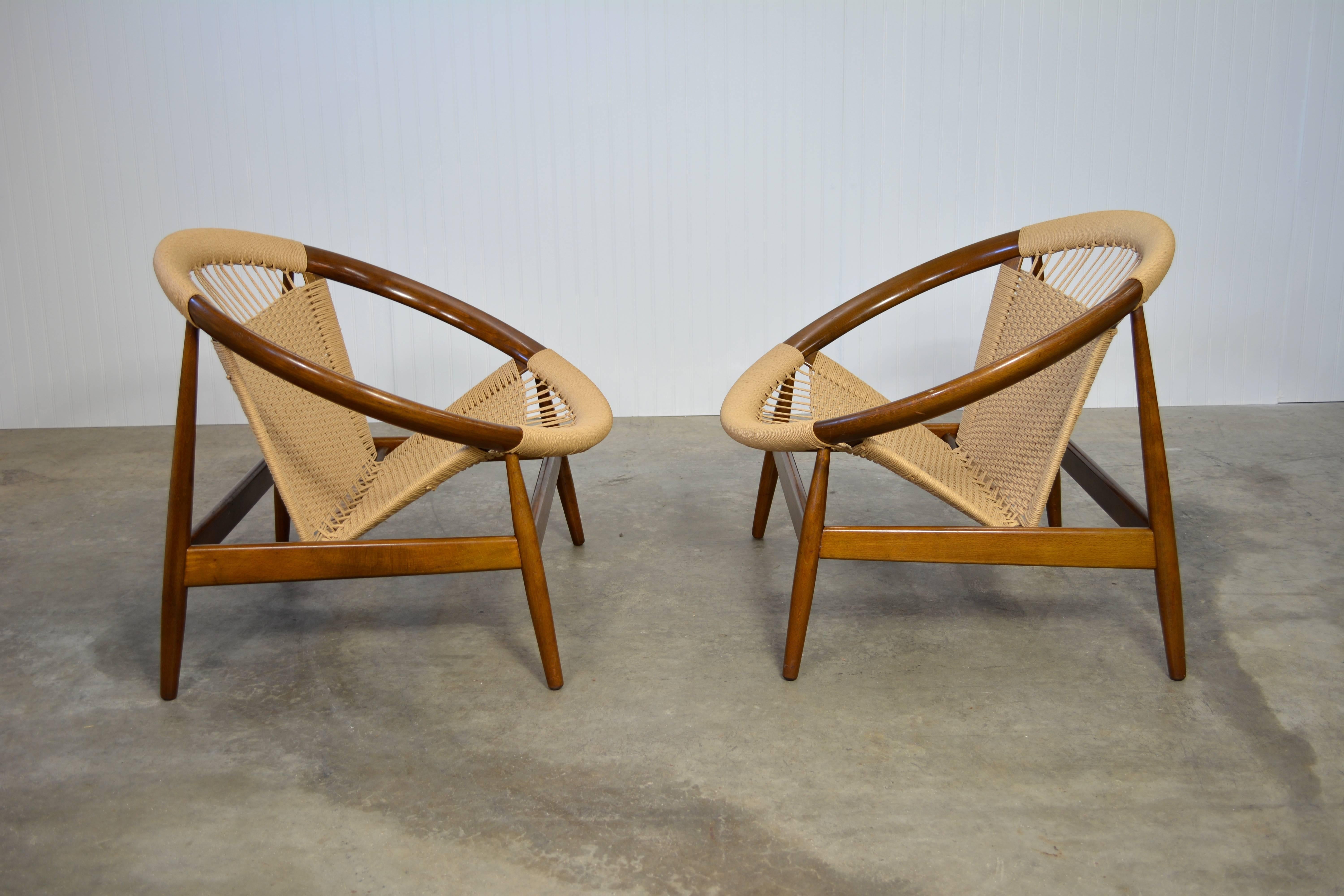 A pair of Illum Wikkelsø "Ringstol" chairs. Walnut frames and cording. Marked "made in Denmark".