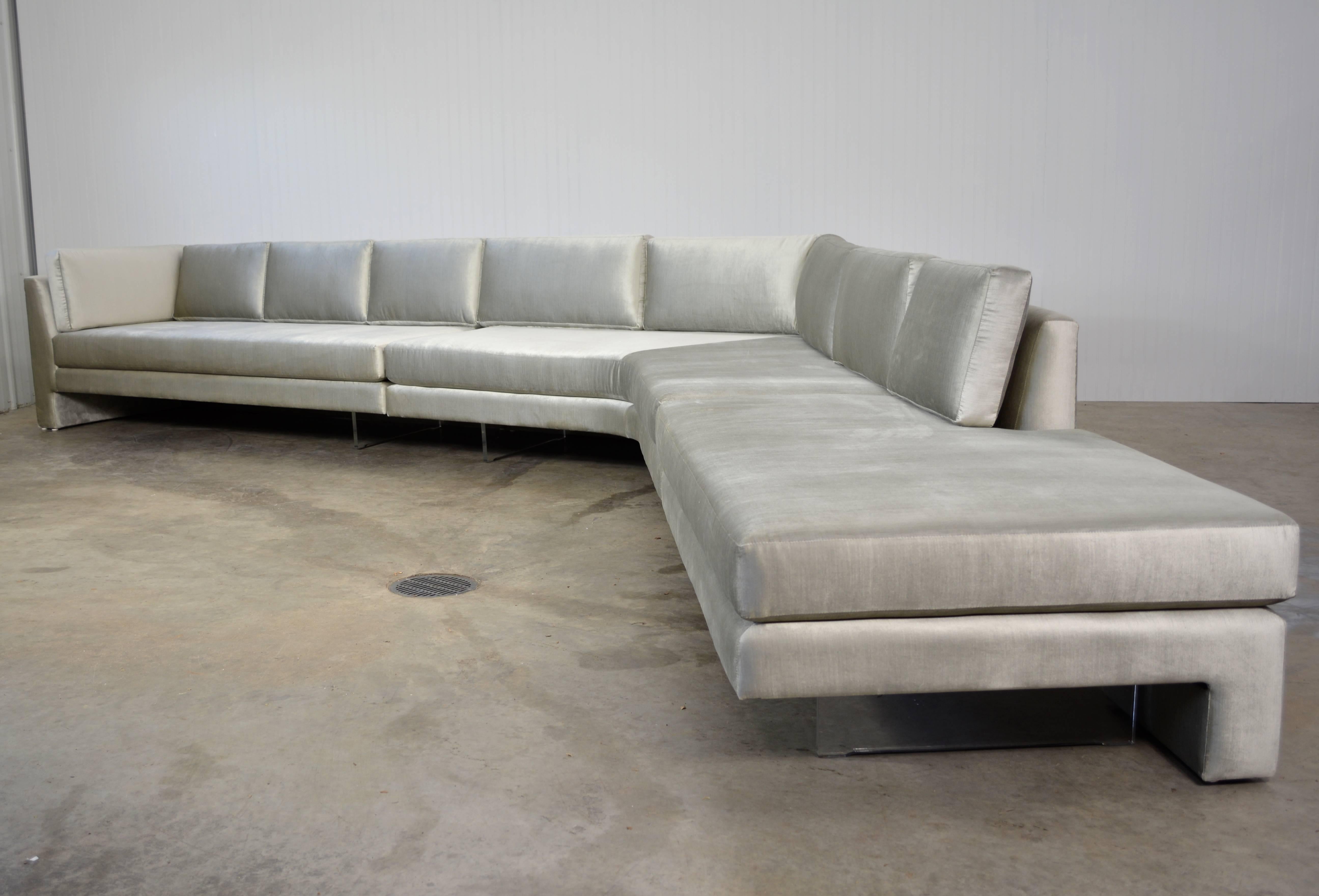 A large three-piece omnibus sectional by Vladimir Kagan for Vladimir Kagan designs. Newly recovered in grey/silver velvet over Lucite support plates.

Each section measures:

79" W x 35.5" D x 31" H
The corner section is 60"