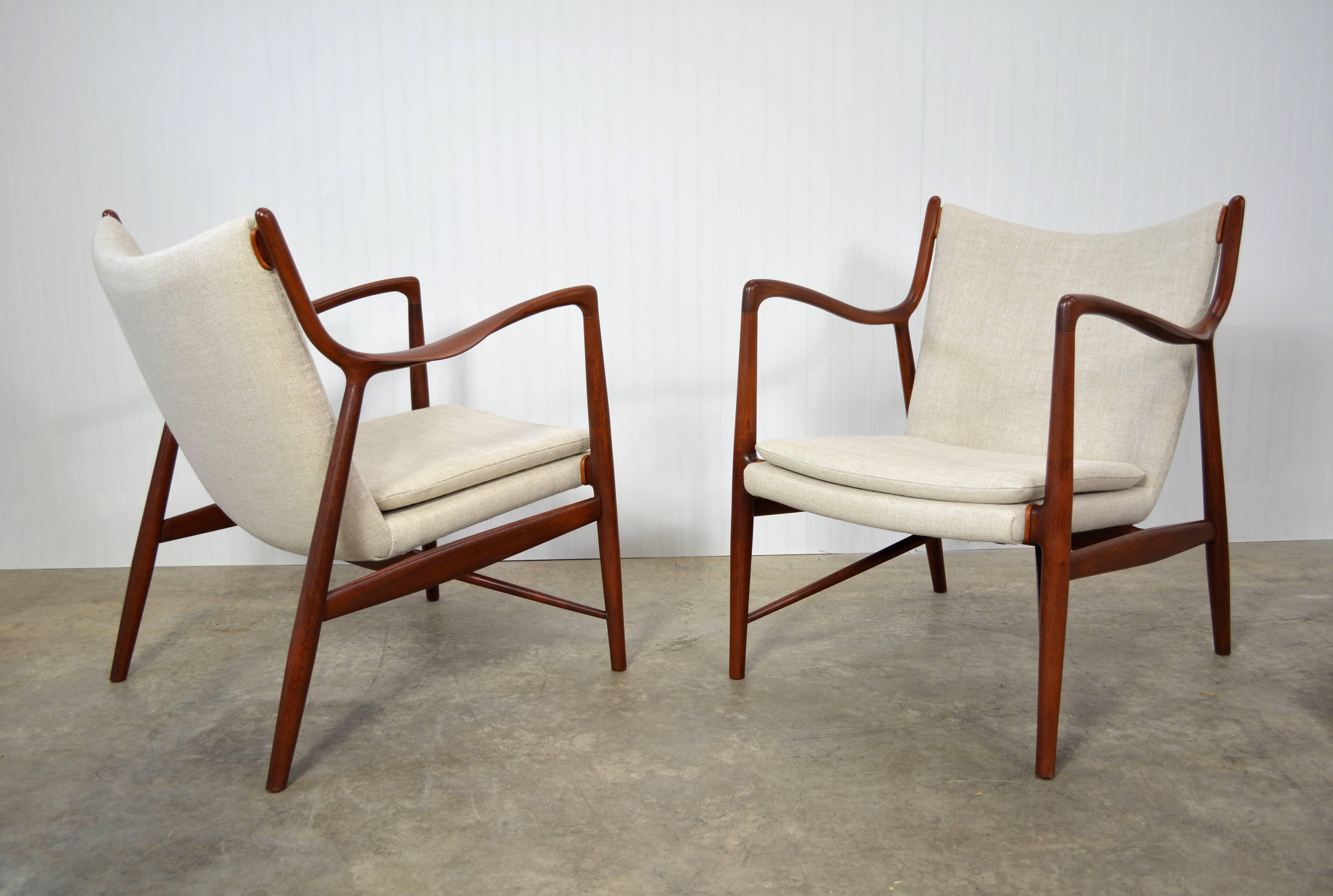 Pair of teak nv-45 lounge chairs designed by Finn Juhl for Neils Vodder. Newly restored and recovered in Belgian linen with cognac leather details.