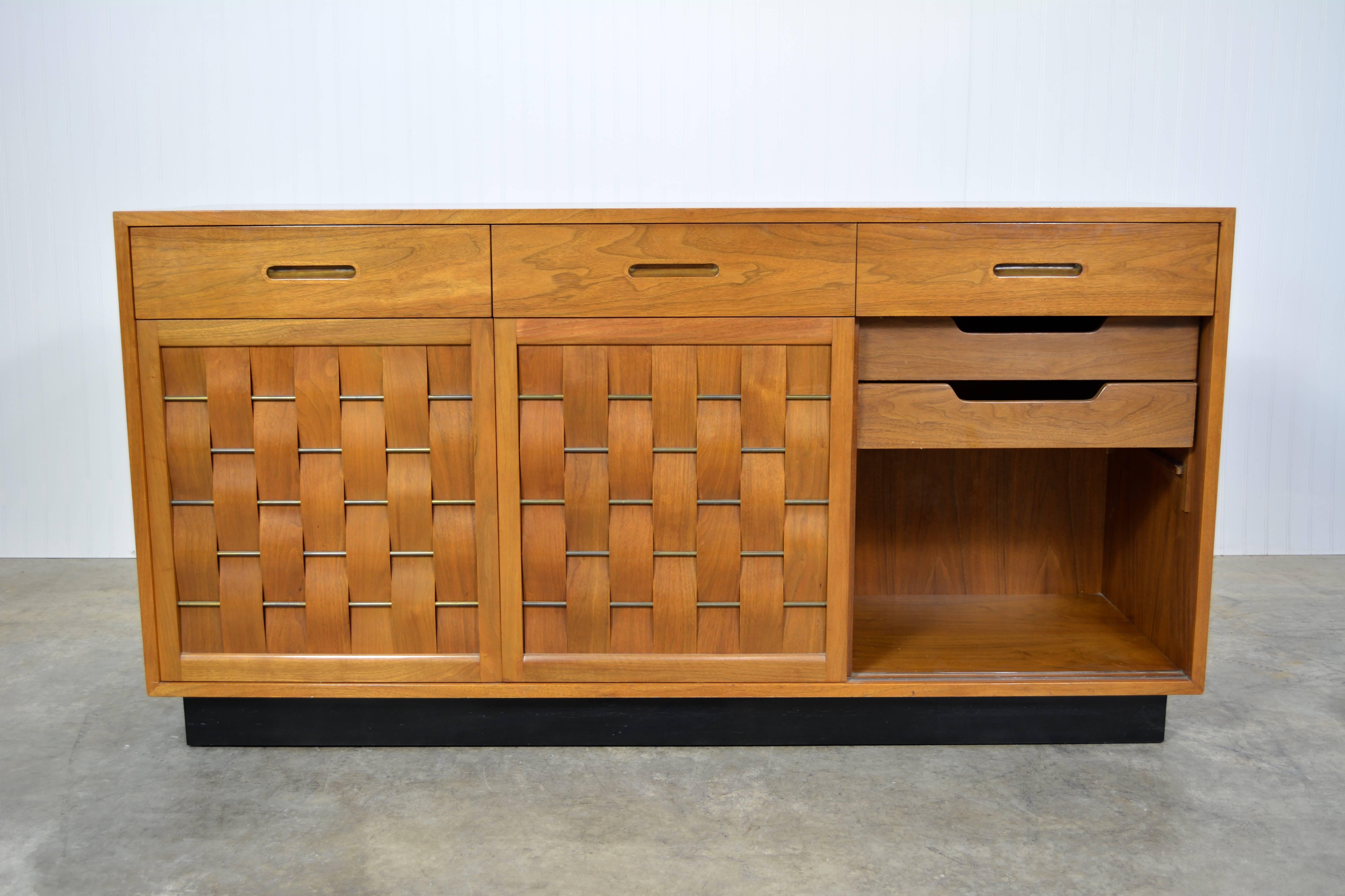 Beautiful mahogany credenza designed by Edward Wormley for Dunbar. Features three woven front sliding doors that reveal ample storage. Above those are three sliding drawers. Original finish.