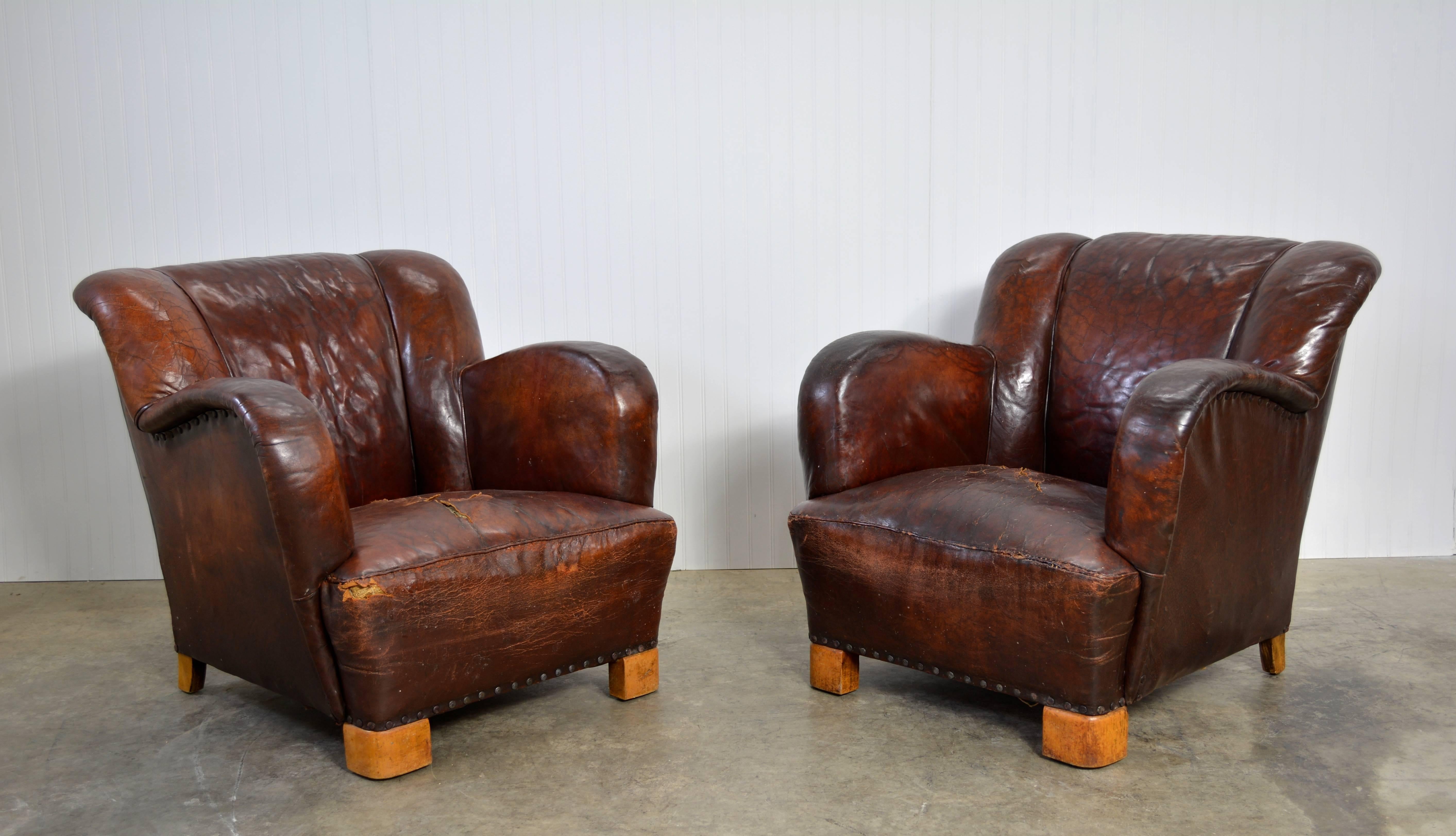 A pair of early Danish lounge chairs upholstered in their original leather.