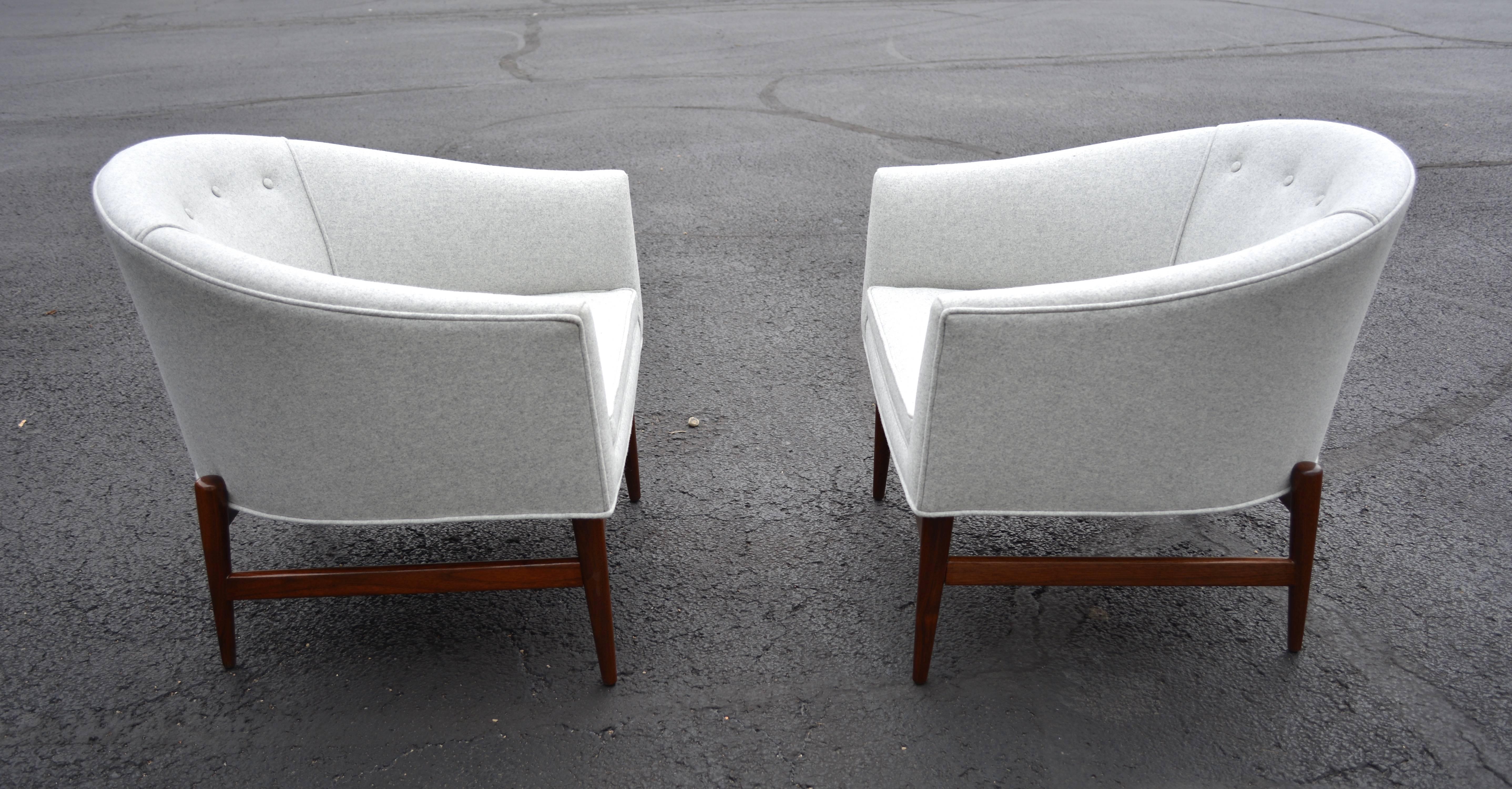 A pair of lounge chairs designed by Lawrence Peabody.  Barrel shaped bodies that have been recovered in a light grey melange wool sit atop refinished solid walnut bases, which gives them a floating appearance.  Newly restored.
