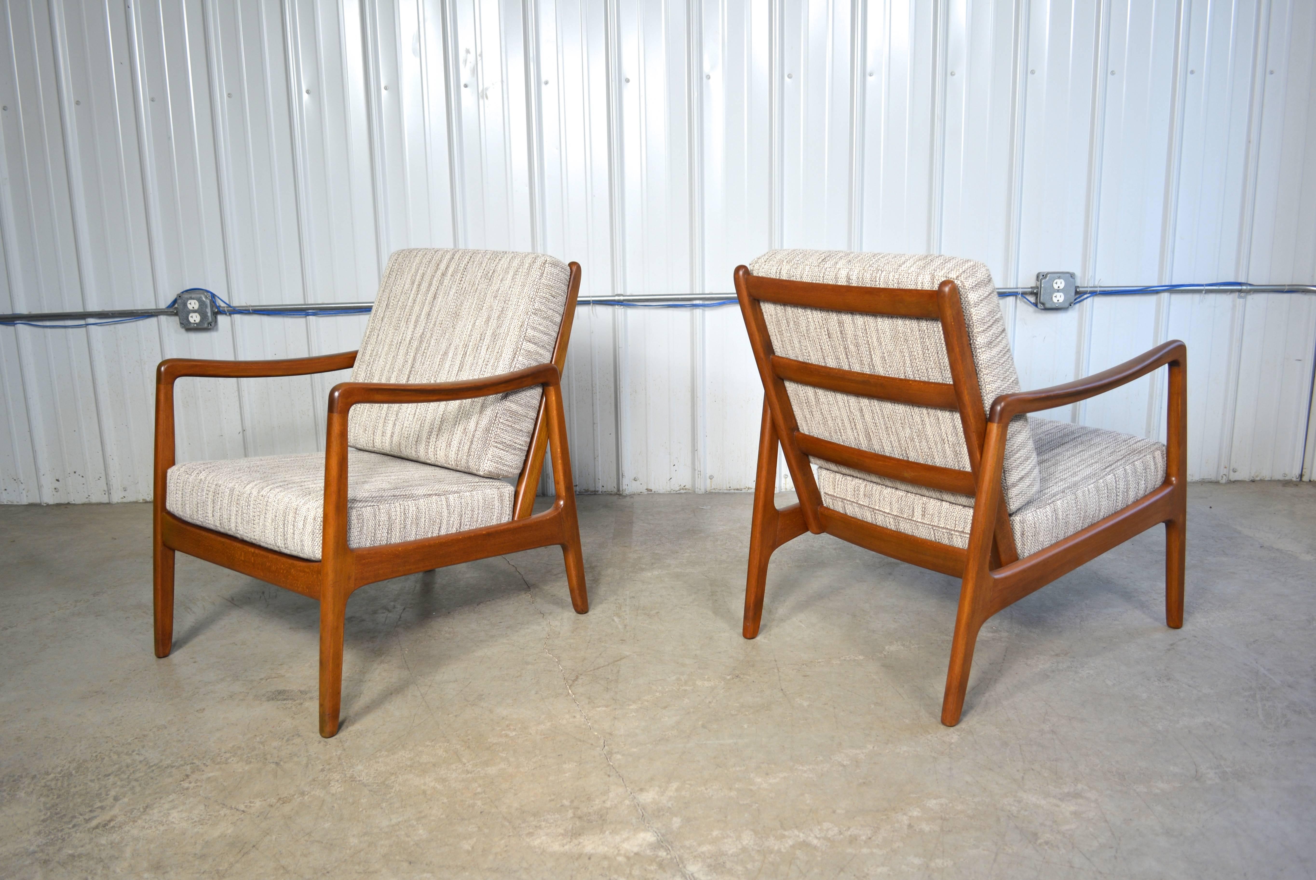 A pair of lounge chairs designed by Ole Wanscher for France & Son.  Simple but elegant Danish Modern design.  The solid beech frames have been refinished.  The cushions have been replaced and reupholstered in a period appropriate wool fabric.