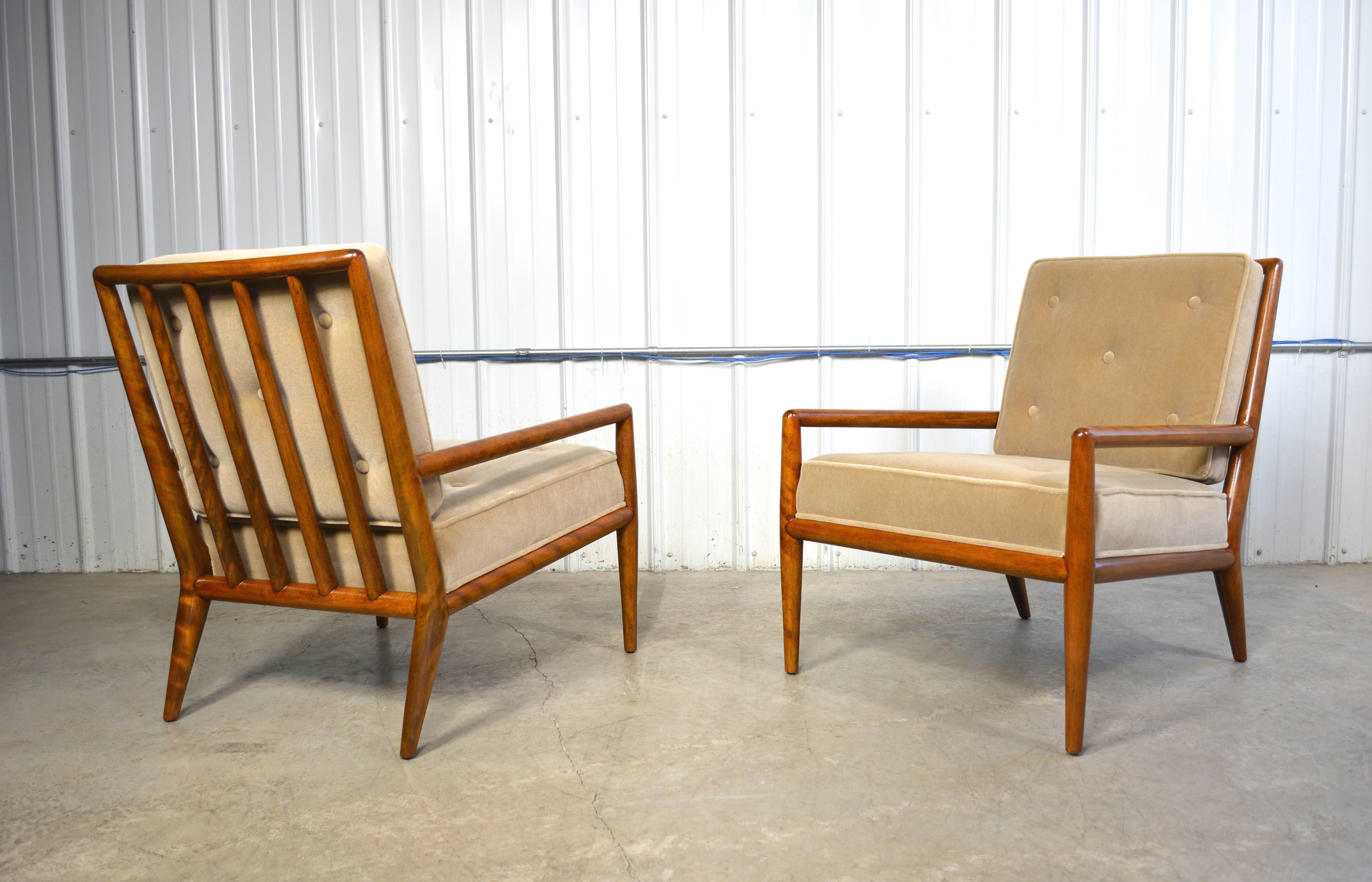 A pair of lounge chairs designed by T.H. Robsjohn-Gibbings for Widdicomb. The solid wood frames have been refinished to reflect their original color. New cushions are upholstered in neutral Belgian mohair.