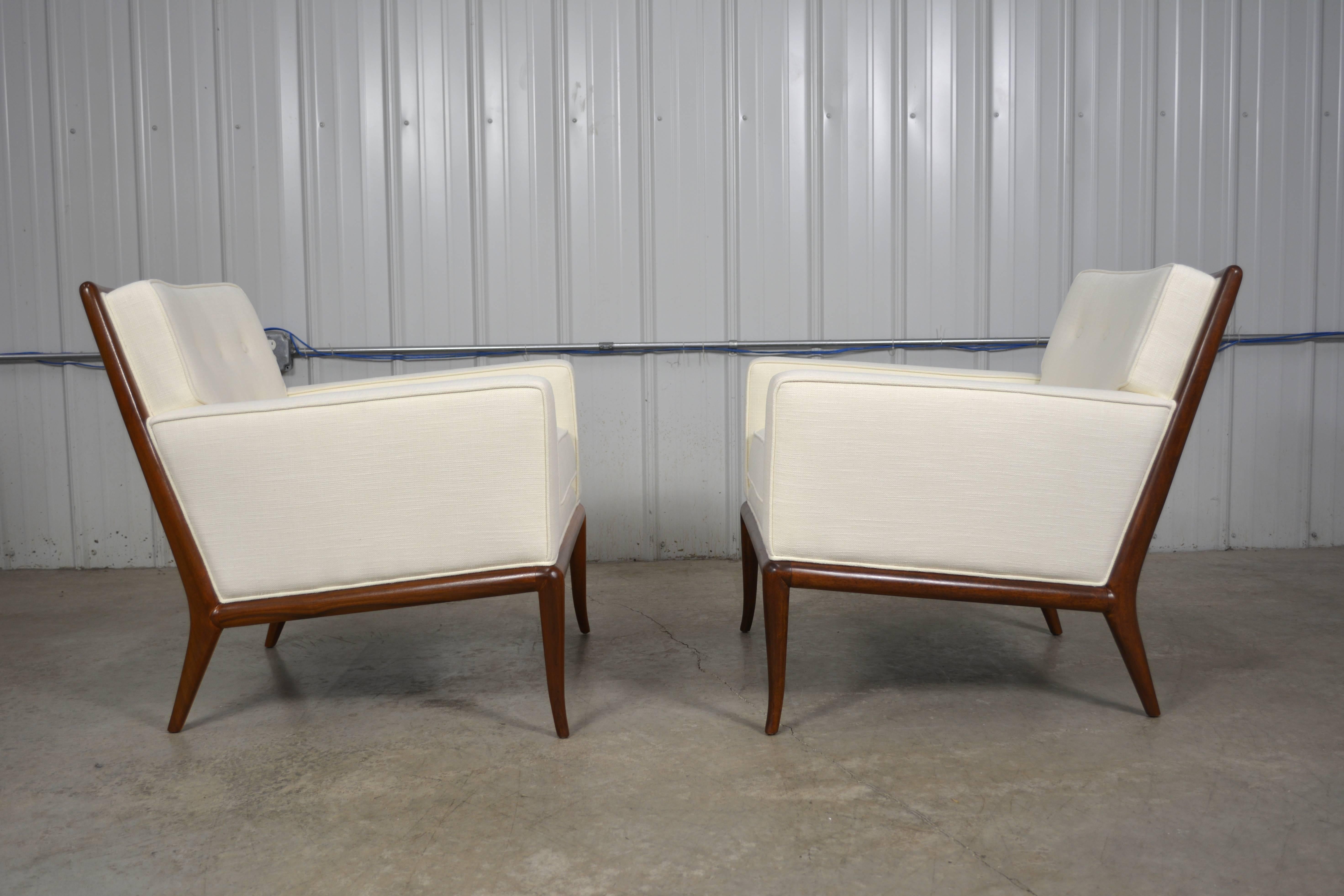 A pair of lounge chairs designed by T.H. Robsjohn-Gibbings for Widdicomb. Walnut frames and new upholstery.