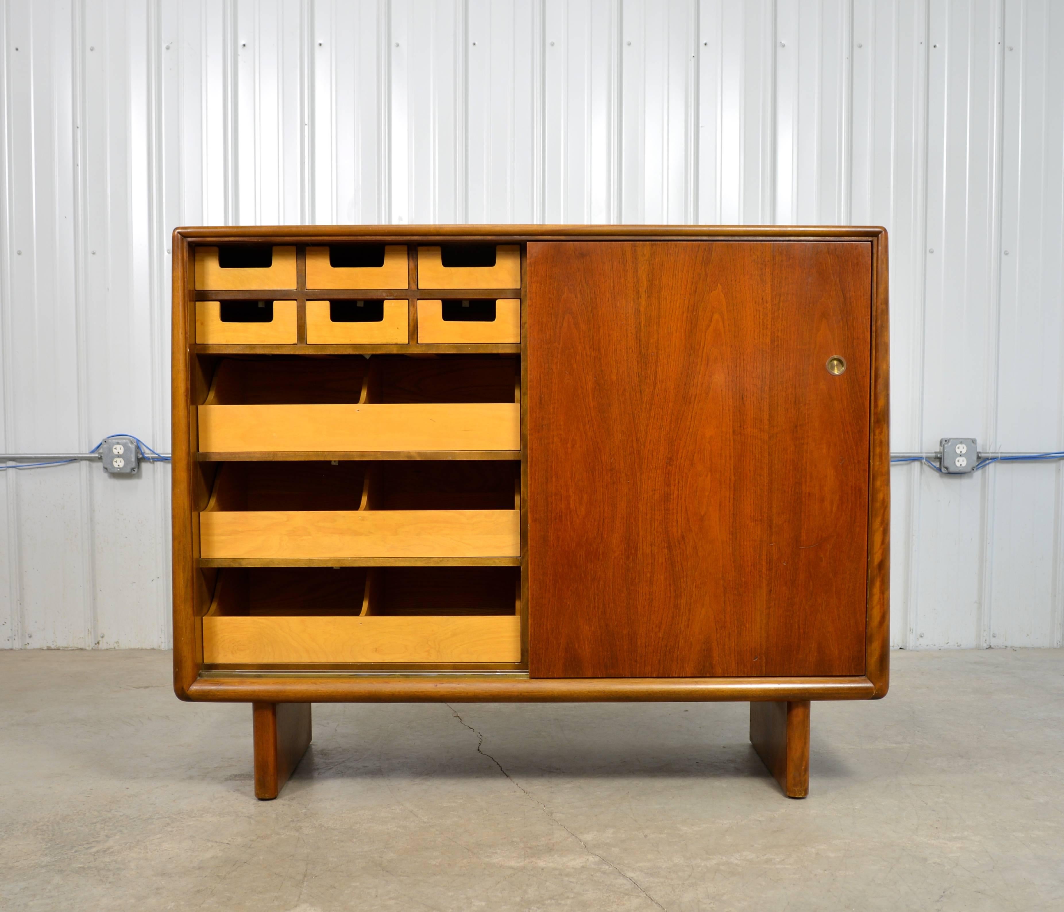 A large gentleman's chest in walnut designed by T.H. Robsjohn Gibbings for Widdicomb.  Unique tapered edges frame this piece.  Sliding doors reveal ample storage space.  Labeled.