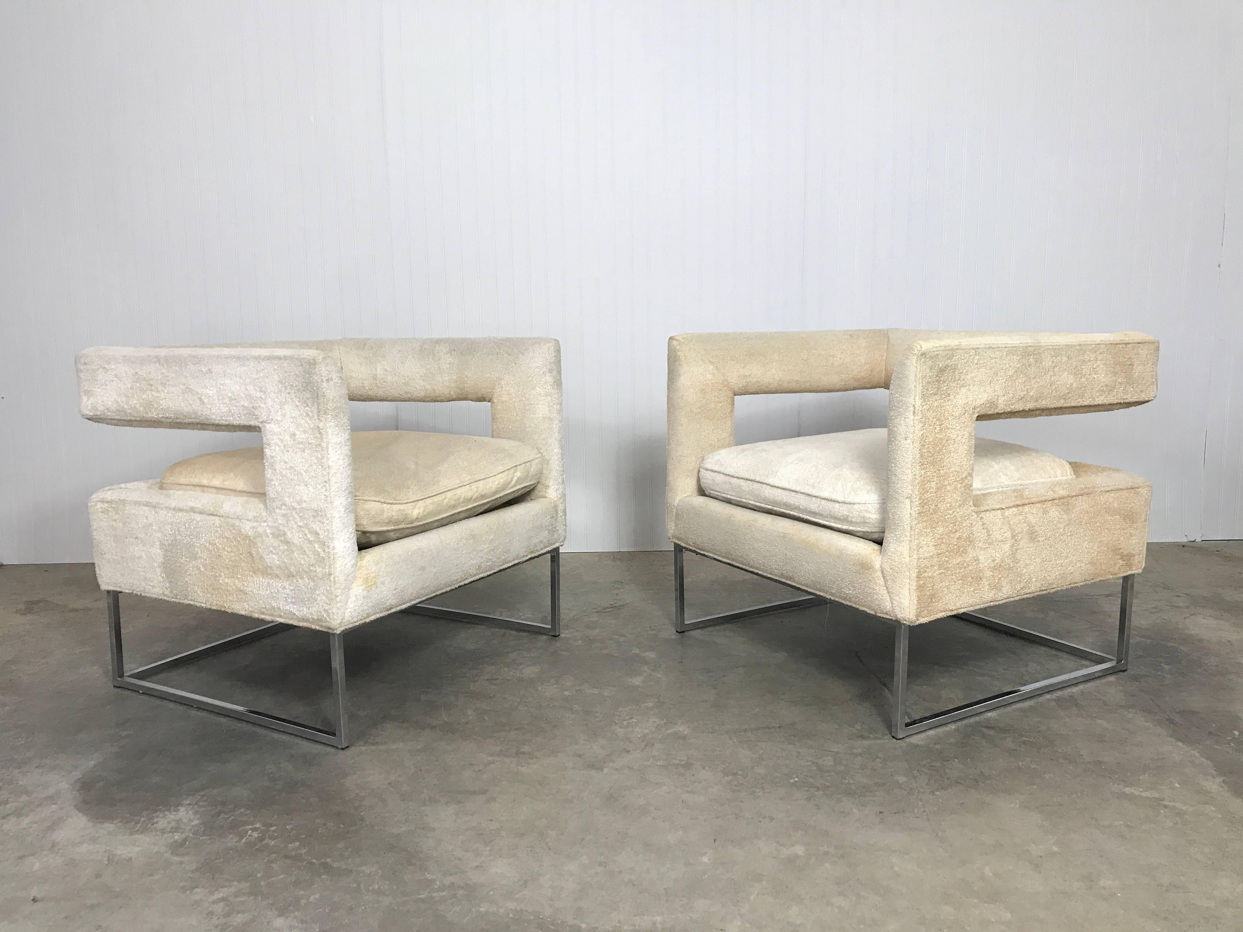 A pair of Milo Baughman sculptural open back lounge chairs on chrome bases.