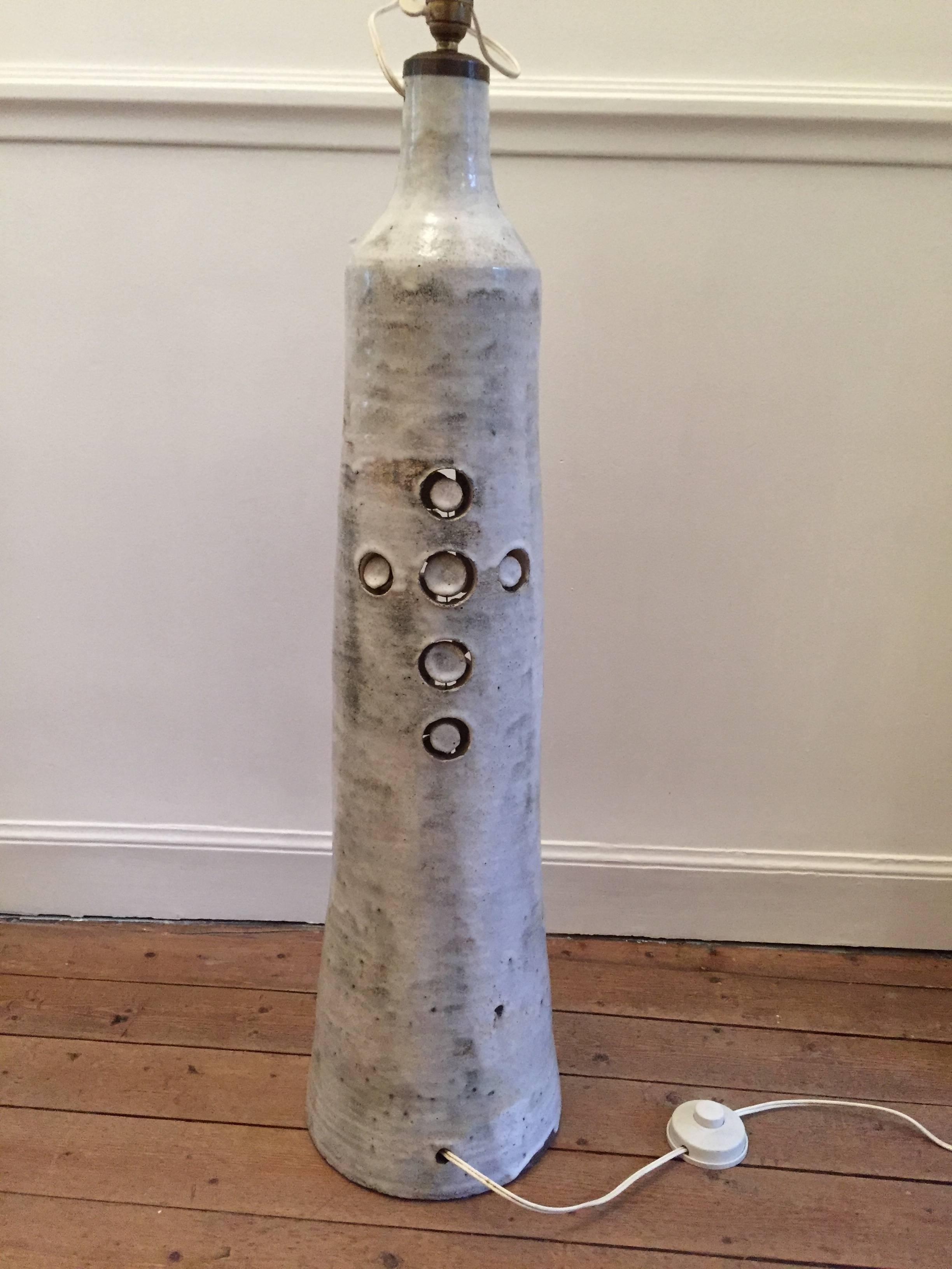 impresive ceramic floor lamp by Georges Pelletier circa 1970 decorated with stylized perforations and unglazed white ceramic pastilles. with original shade,perfect vintage condition

Dim lamp = H 83 / Diam 23 cm

Dim shade = H 80 / diam 45 cm