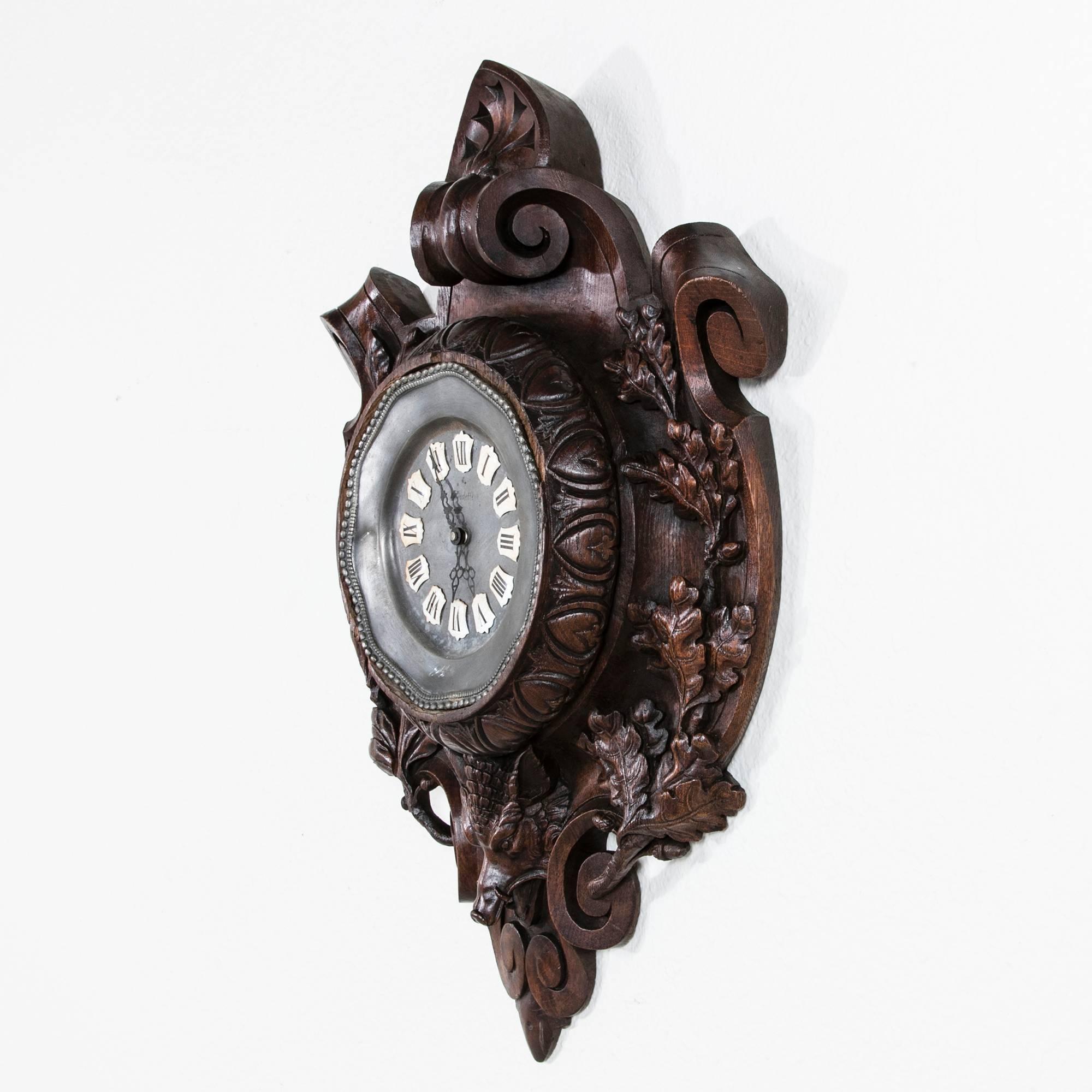 This fantastic 19th century hand-carved oak Black Forest clock features a central wild boar's head with surrounding oak leaf and acorn ornamentation on its shield shaped form. The central pewter clock face was probably added at some point in the