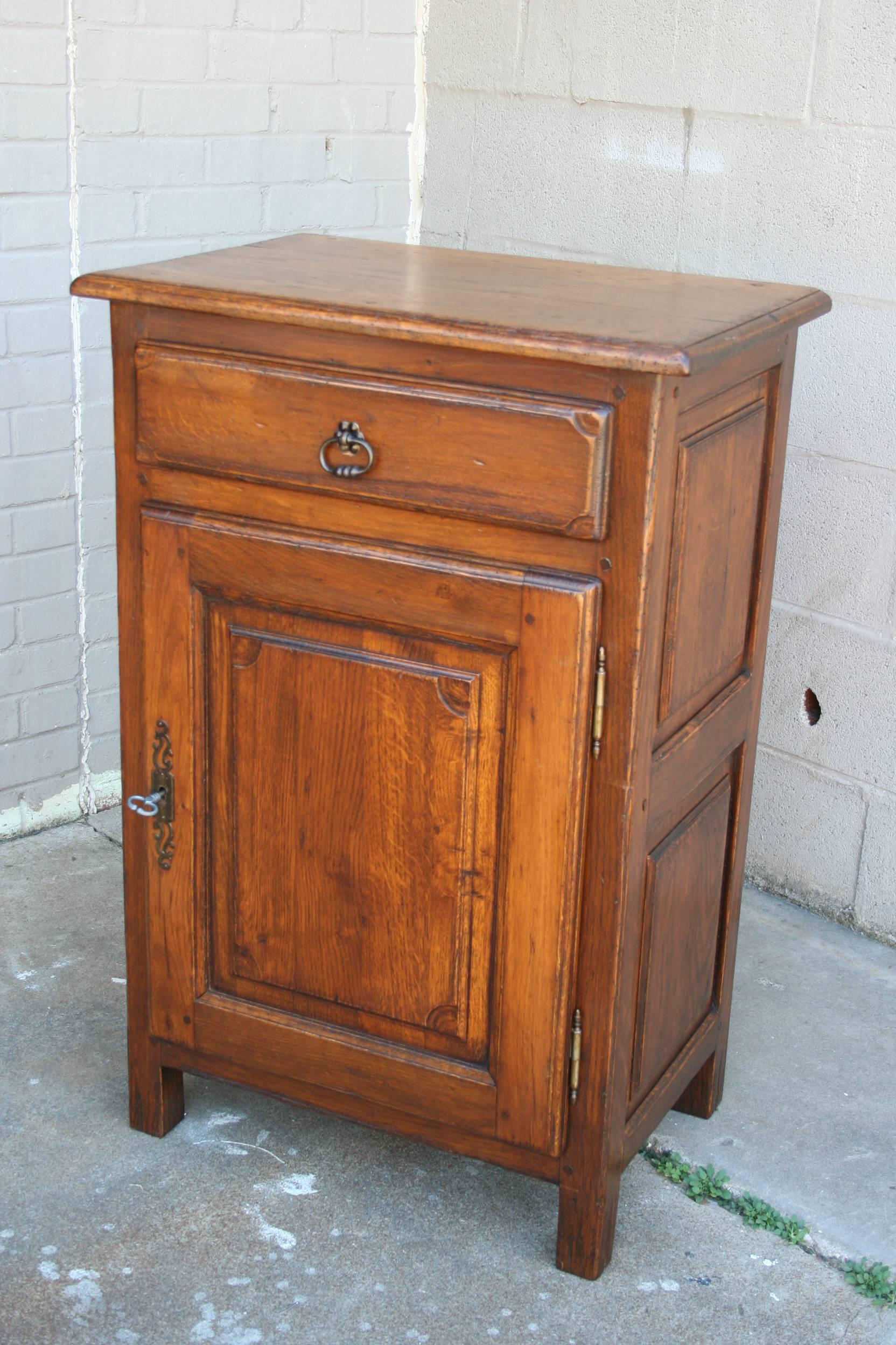 A warm and primitive feeling piece, this Louis XIV style jam cabinet is of a versatile scale for use in a pantry, as a side table, or as a nightstand. Beautifully aged, with hand pegged construction, this cabinet will add a sense of history and