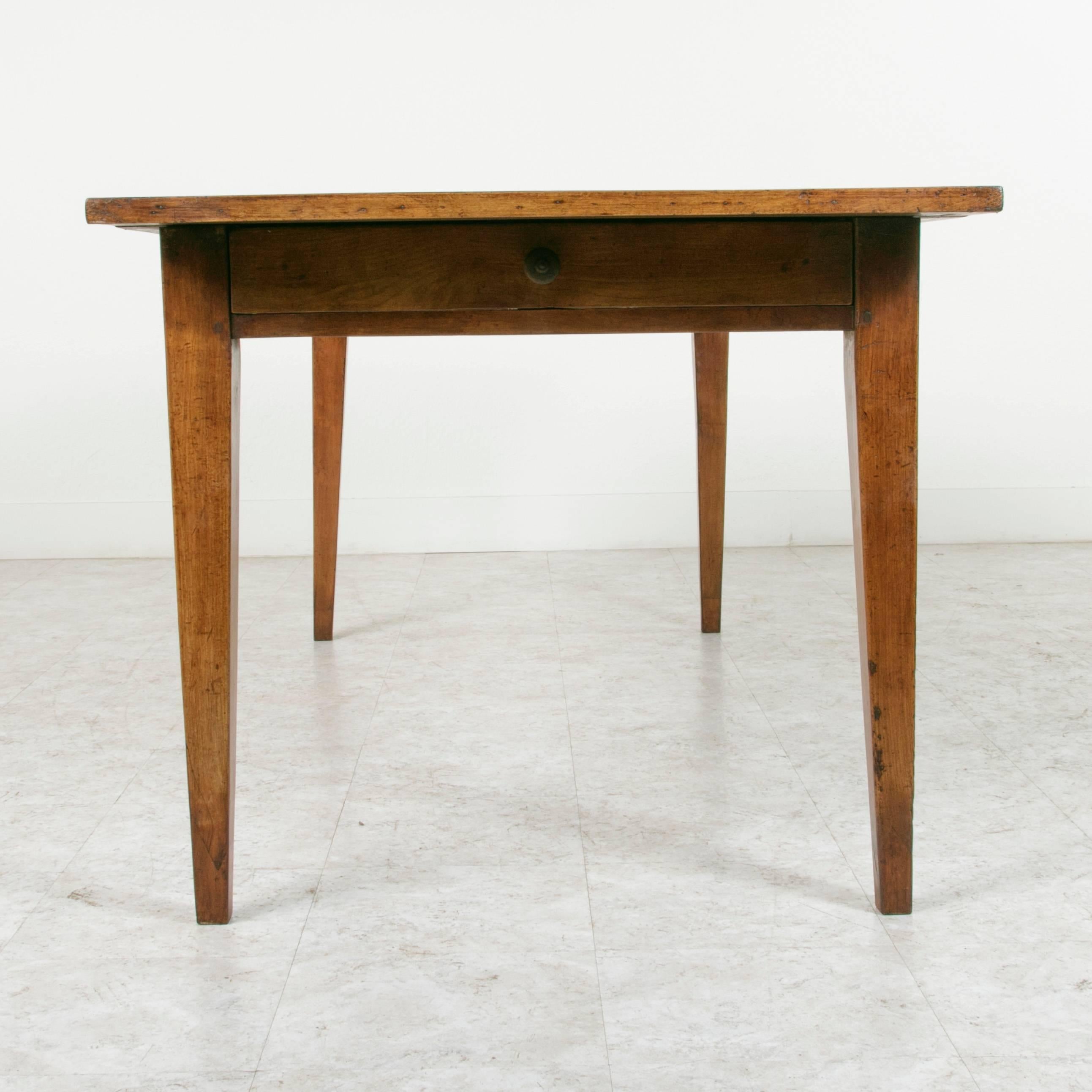 This artisan made farm table has a hand pegged cherry wood base with a walnut and beech top. This piece features a long drawer at each end and simple elegant lines. The age of this table gives it a wonderful warm feeling and at six and a half feet